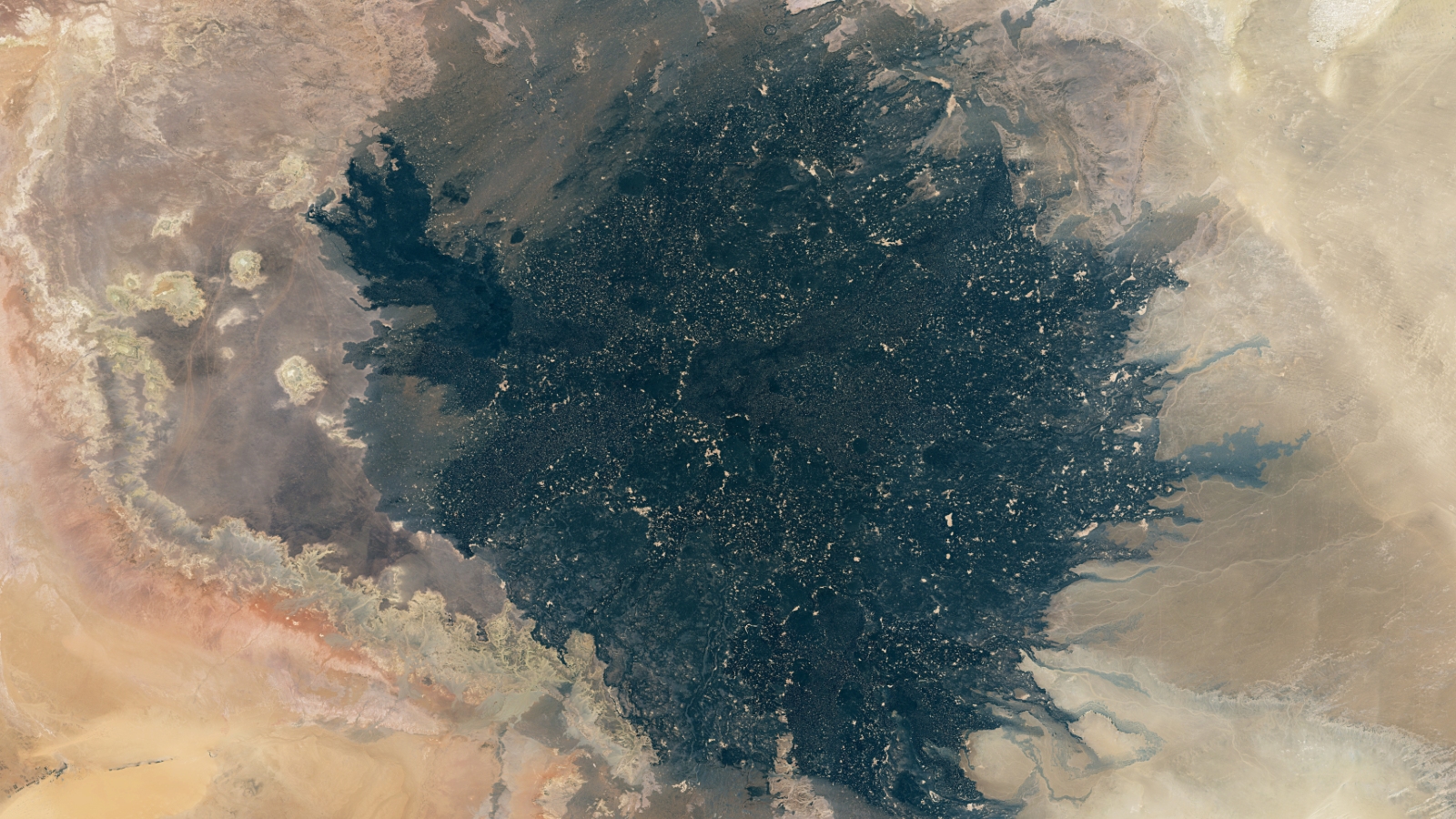 Une photo satellite d’une plaque géante de lave noire dans un désert