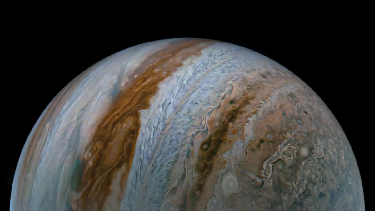 closeup spacecraft photo of half of jupiter, showing its bands of clouds in stripes of silvery-white and reddish-brown