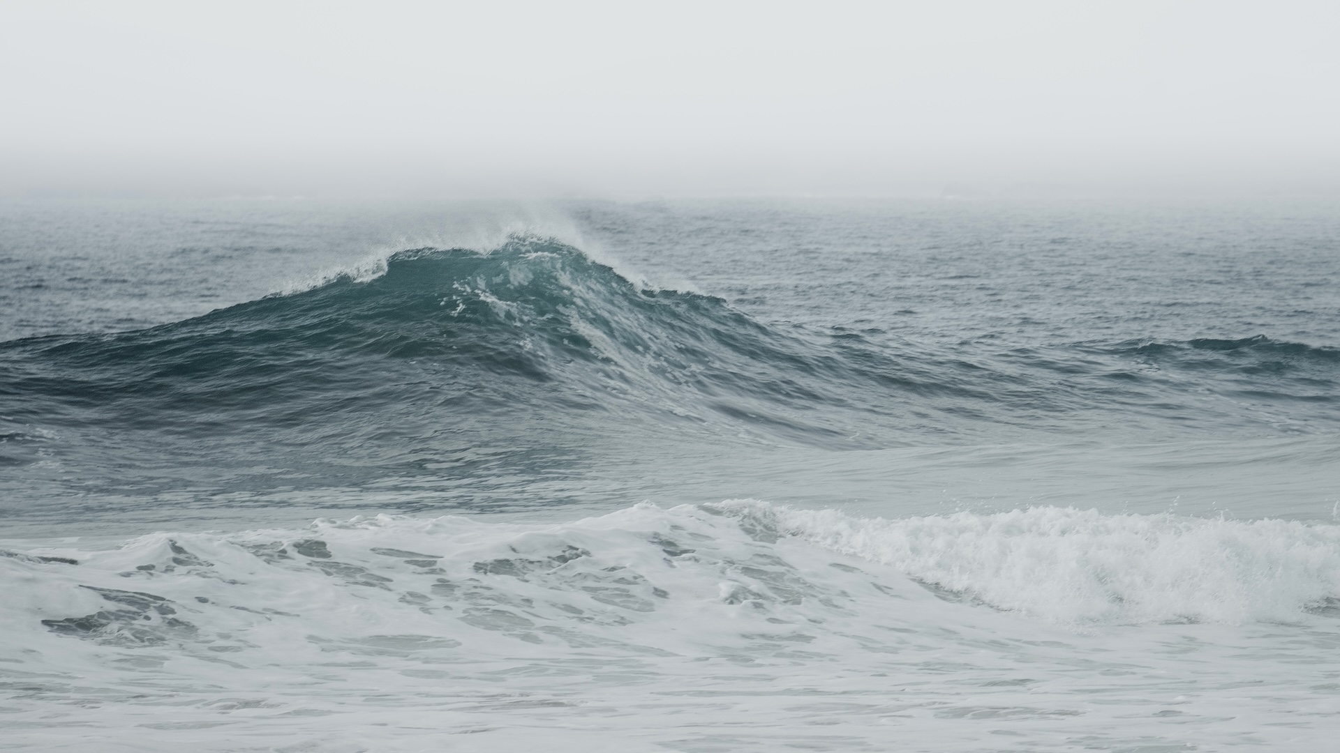 a photo of a large breaking wave on the open ocean