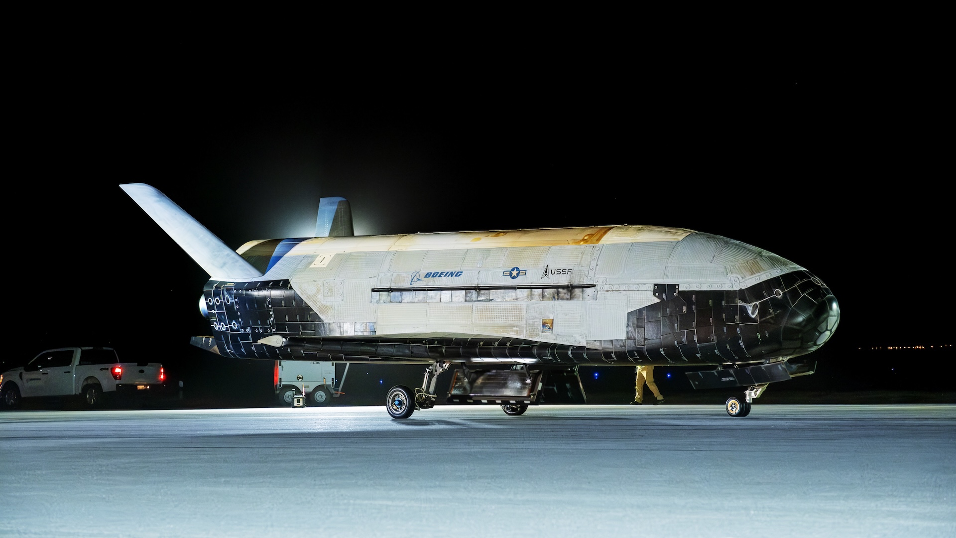 Une photo de l'avion d'espace x37-B sur un tarmac la nuit