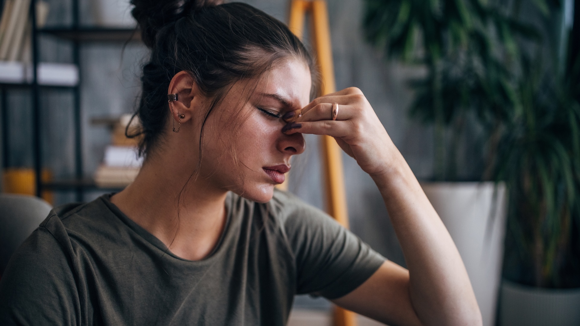 a woman with her headache holds her forehead