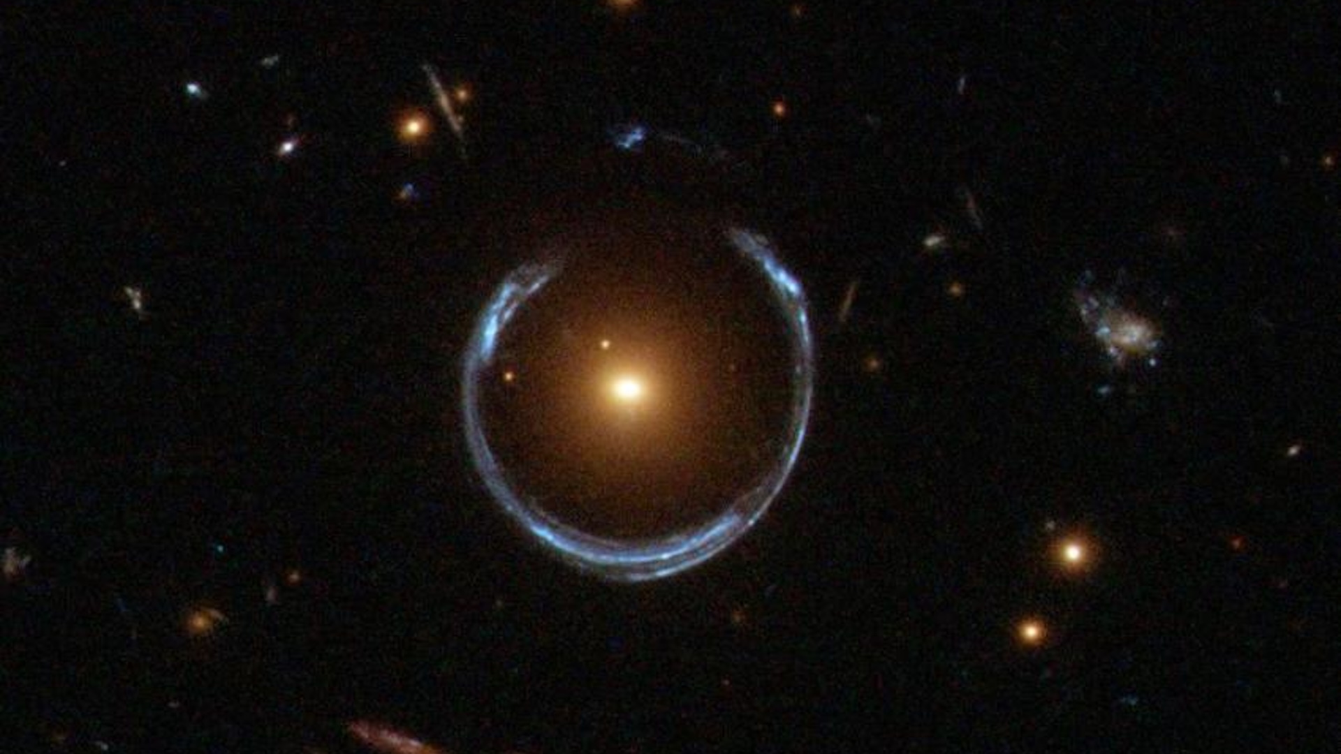 Une image d'un objet dans l'espace avec une forme qui ressemble à un fer à cheval avec une grande lumière brillante au milieu