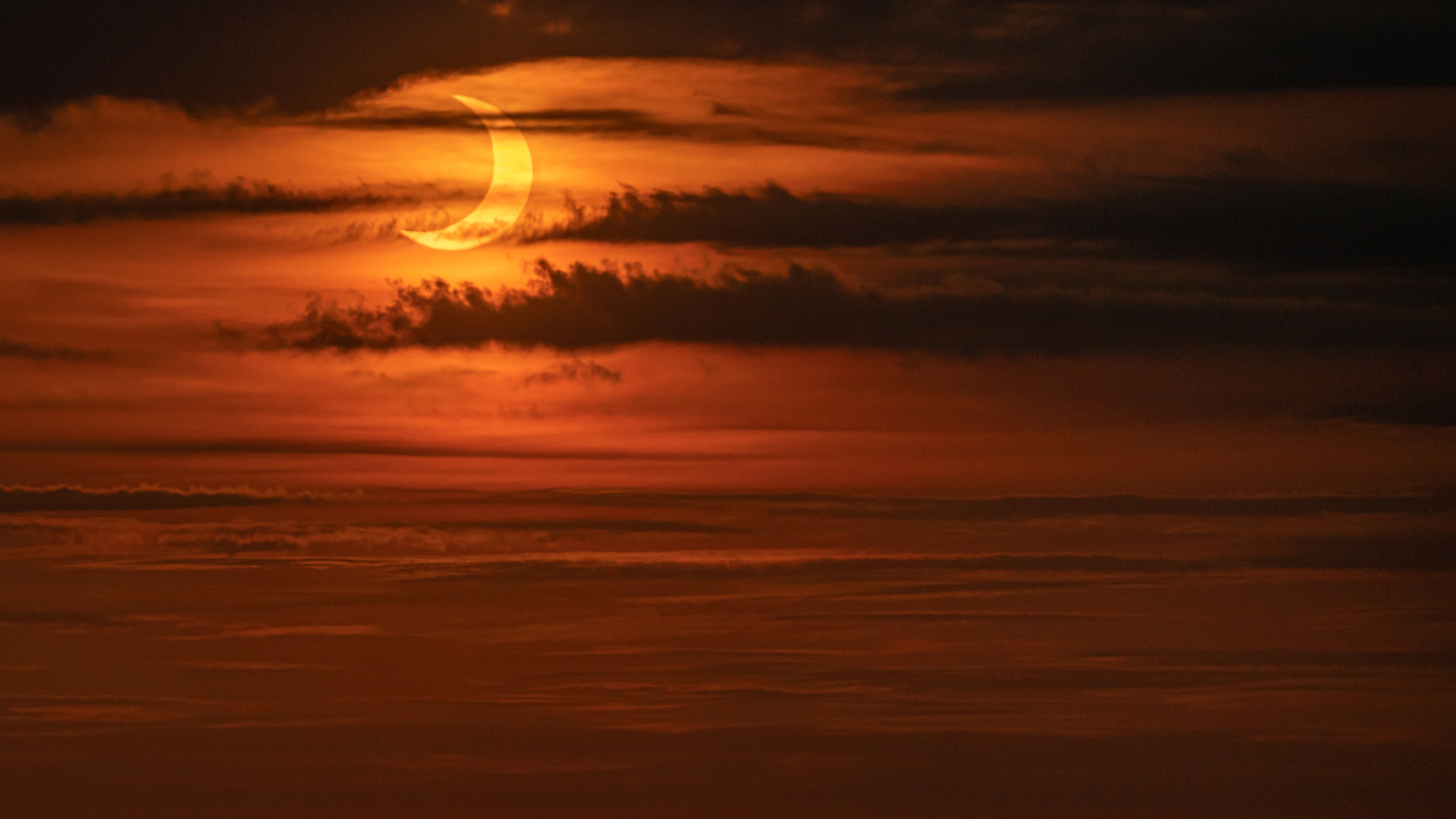 Le Soleil se lève lors d'une éclipse solaire vu du pont de l'observatoire Edge aux Hudson Yards le 10 juin 2021 à New York.