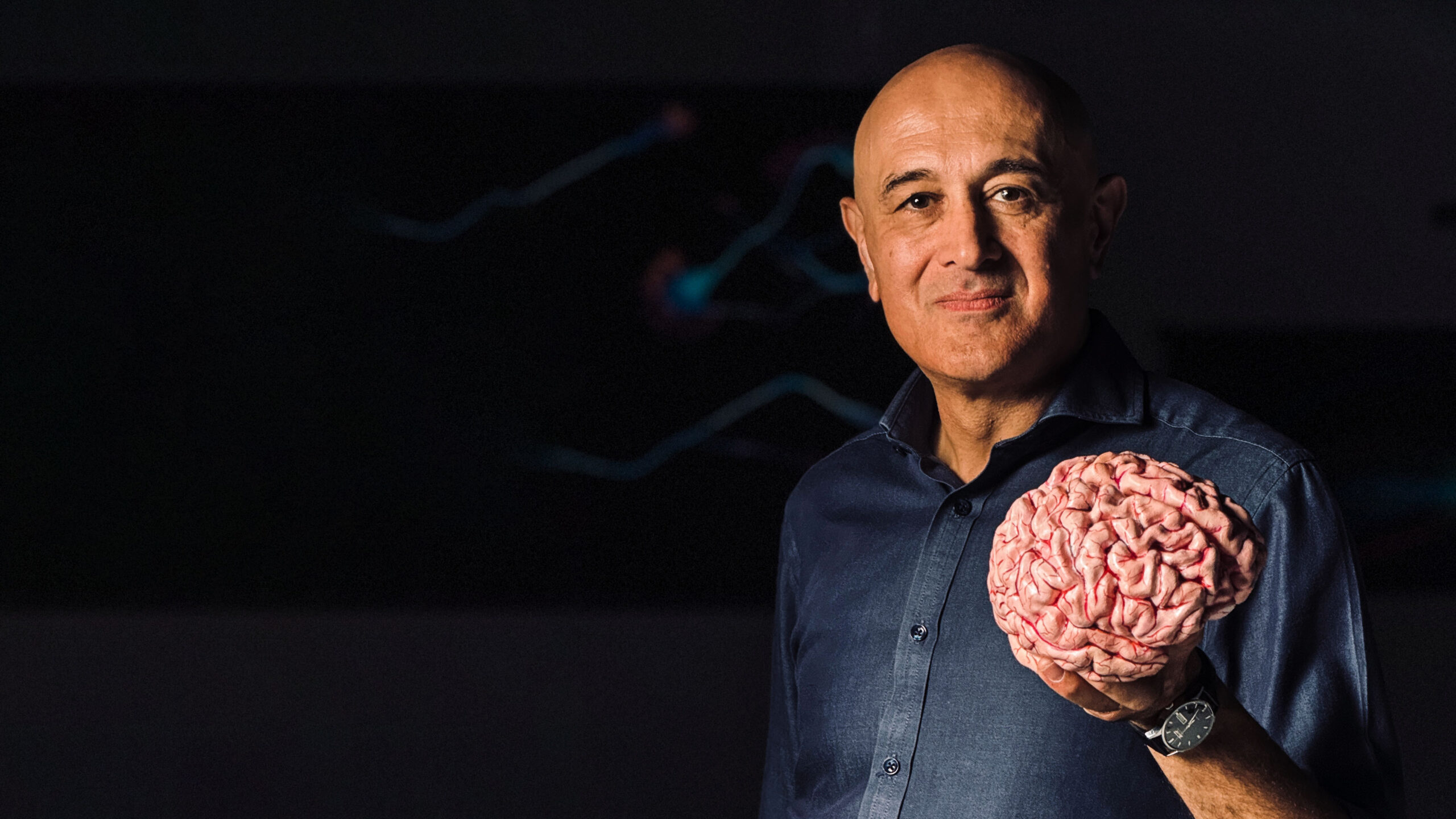 Professor Jim Al-Khalili holding a 3D printed brain in his left hand.