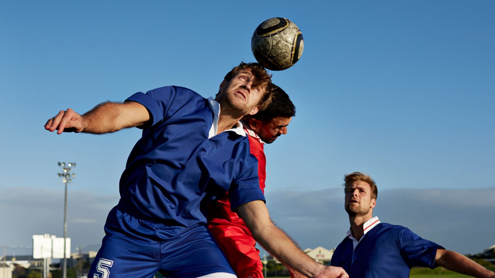 Two soccer players battling to head the ball