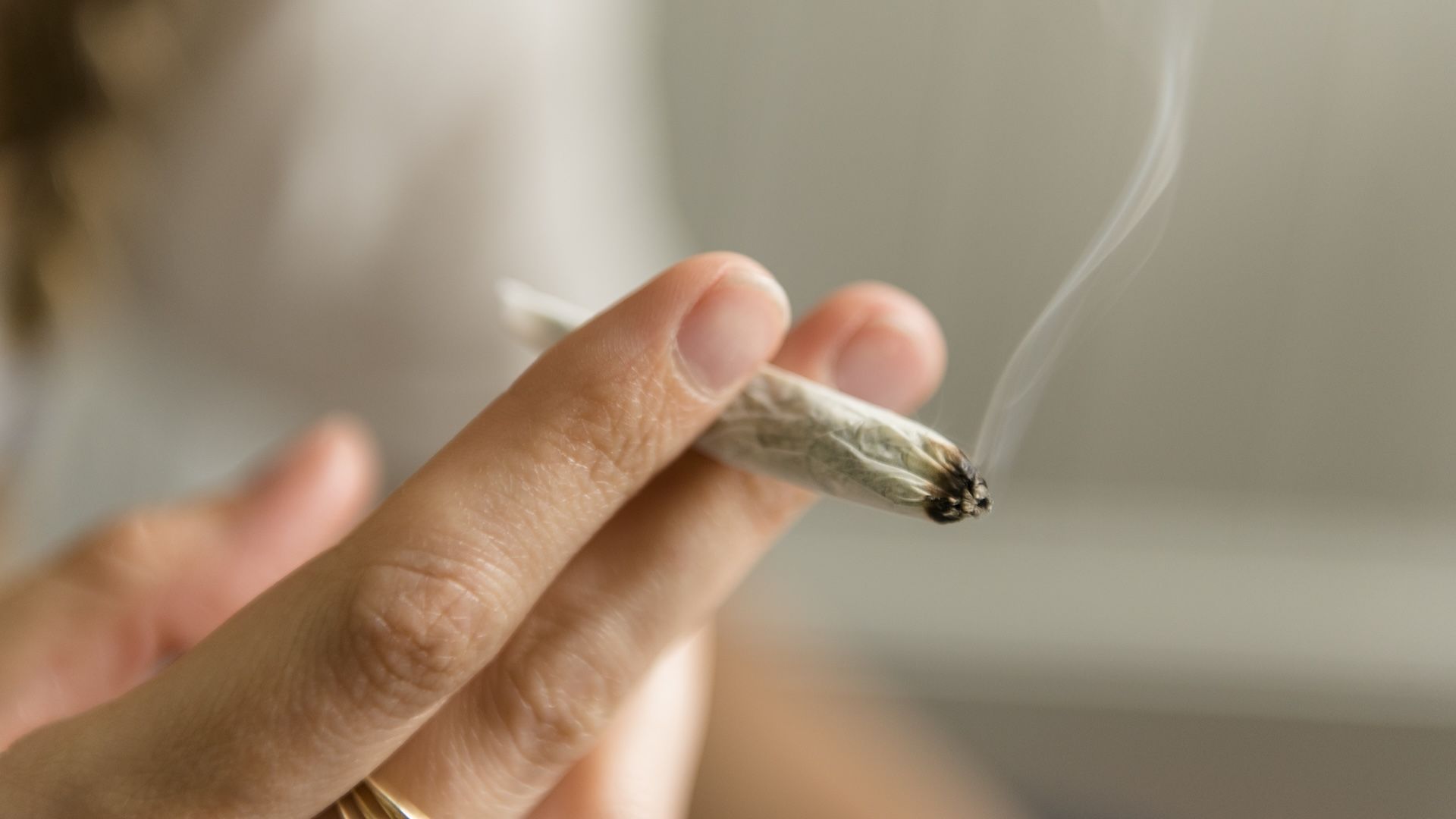 a close-up of a woman's hands holding a joint