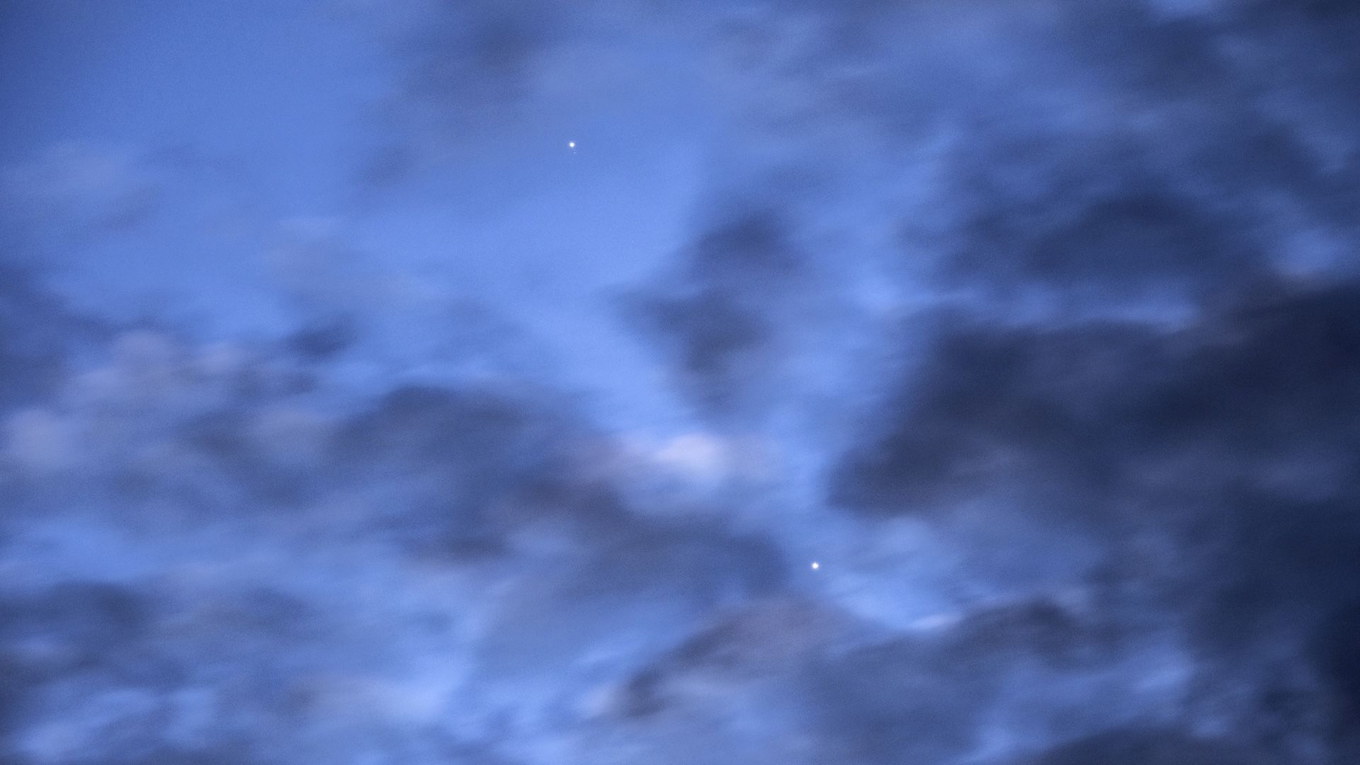 a photo of the sky at dawn with Mercury and Venus visible behind dark clouds
