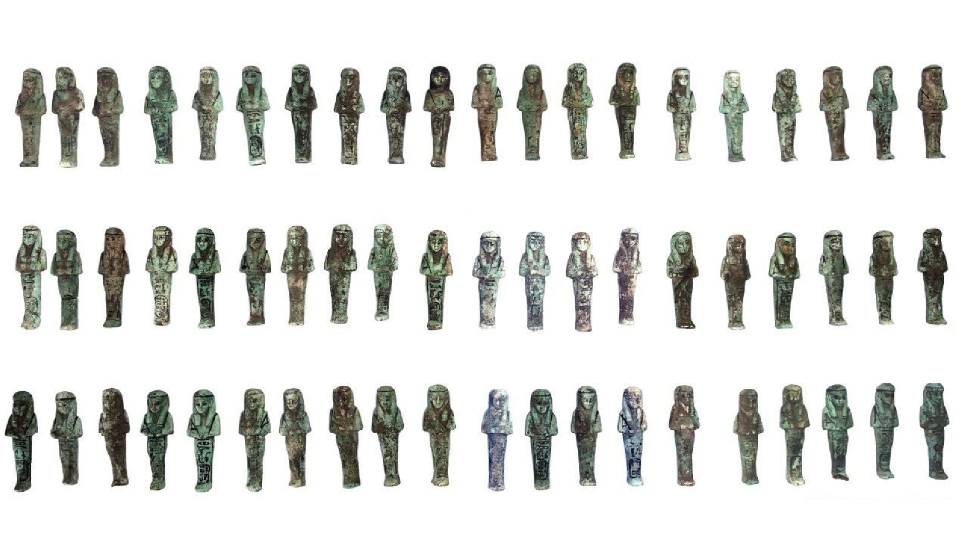 Dozens of shabti figurines lined up against a white background