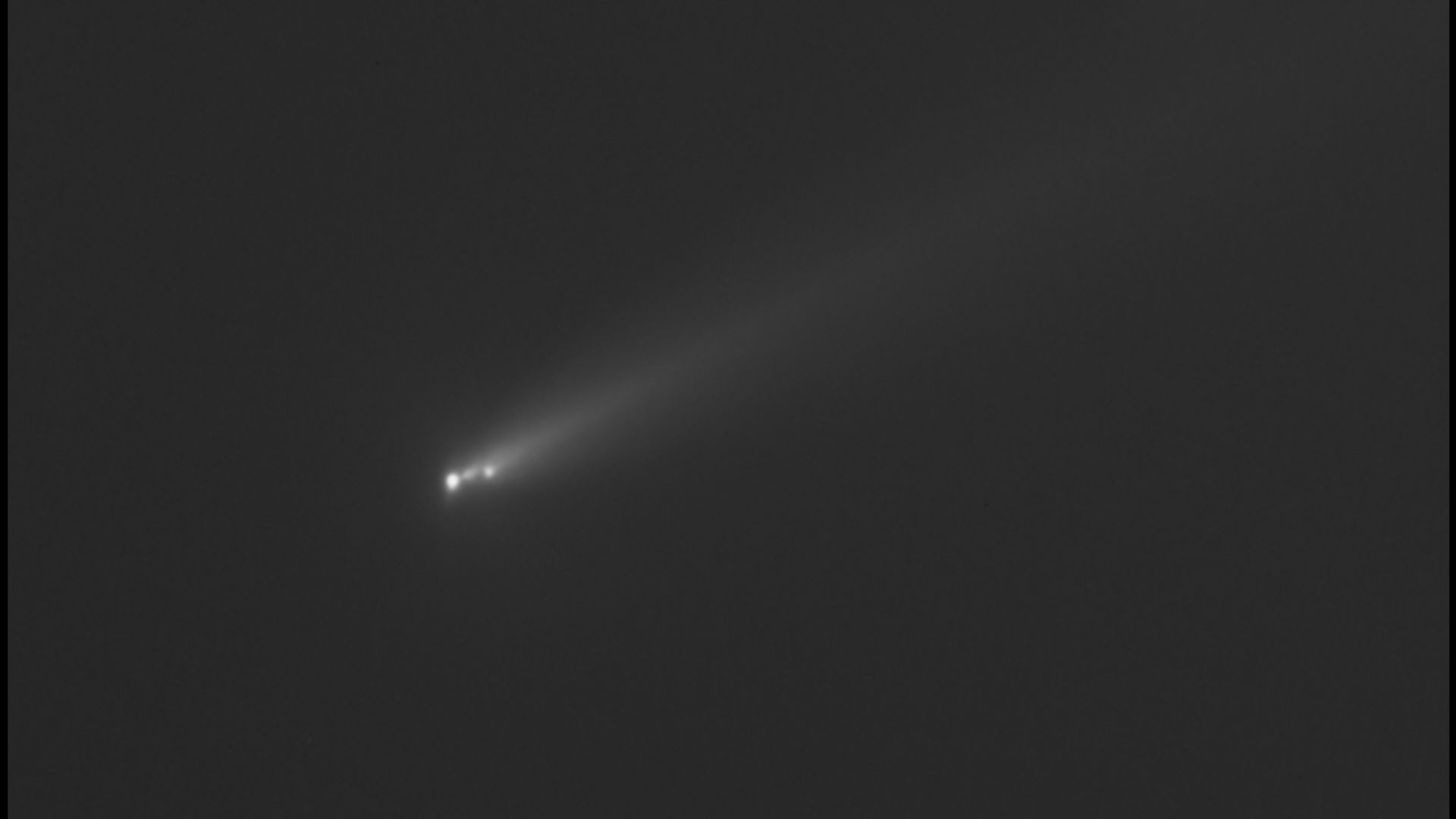 a black and white image of a comet streaking through outer space
