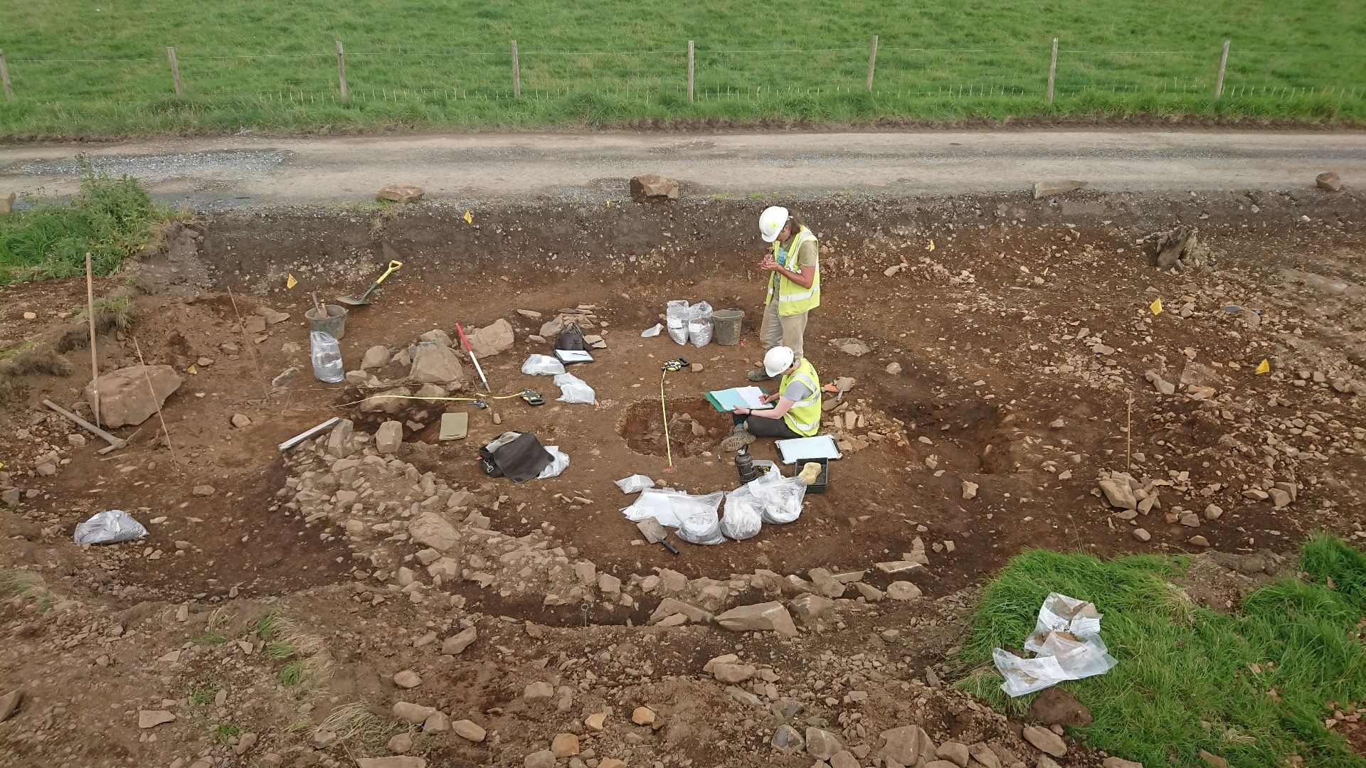 Archaeologists at the excavation site around the broken urns that contained the remains.