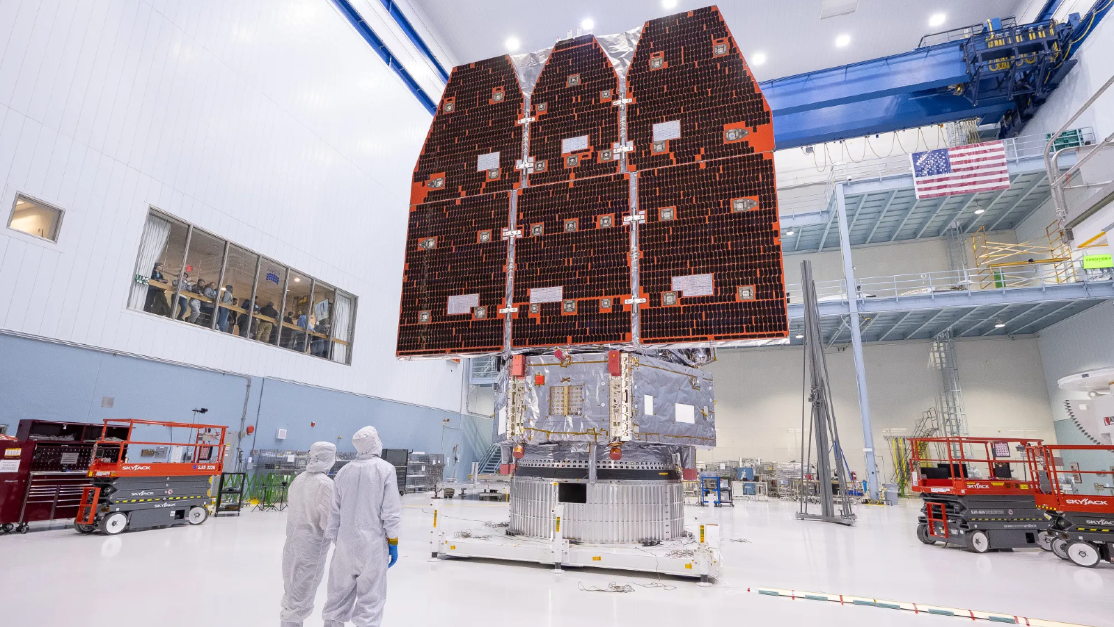 Deux scientifiques se tiennent devant le télescope spatial romain entièrement terminé