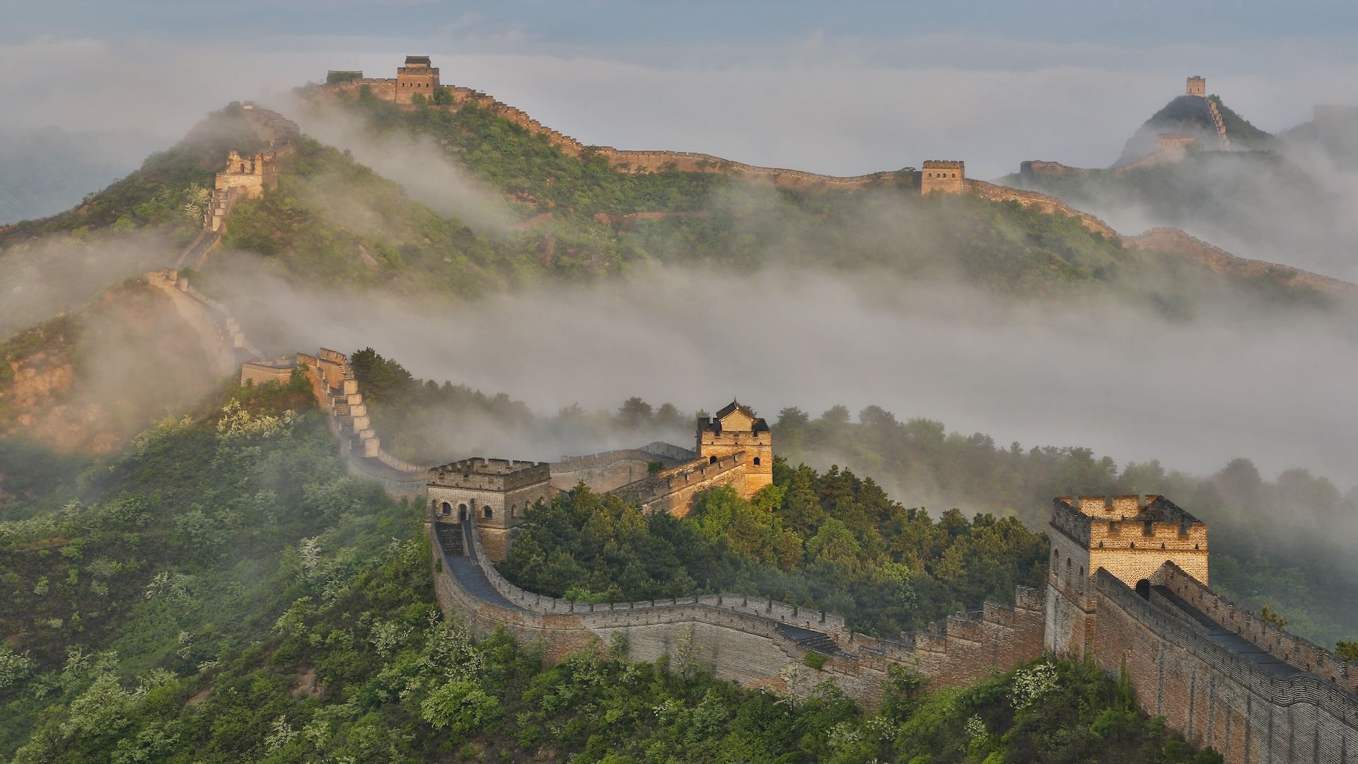 an aerial image of the Great Wall of China on a foggy day