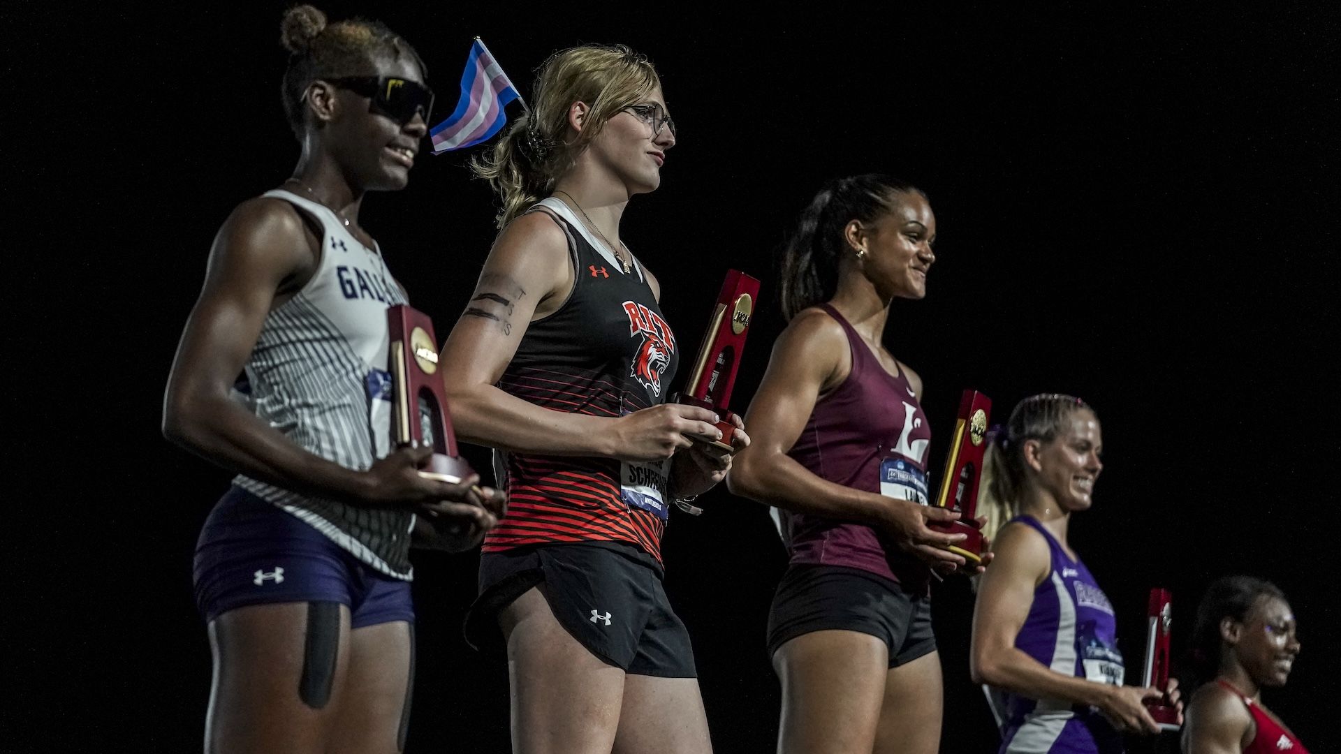 Five track athletes on a podium getting awards