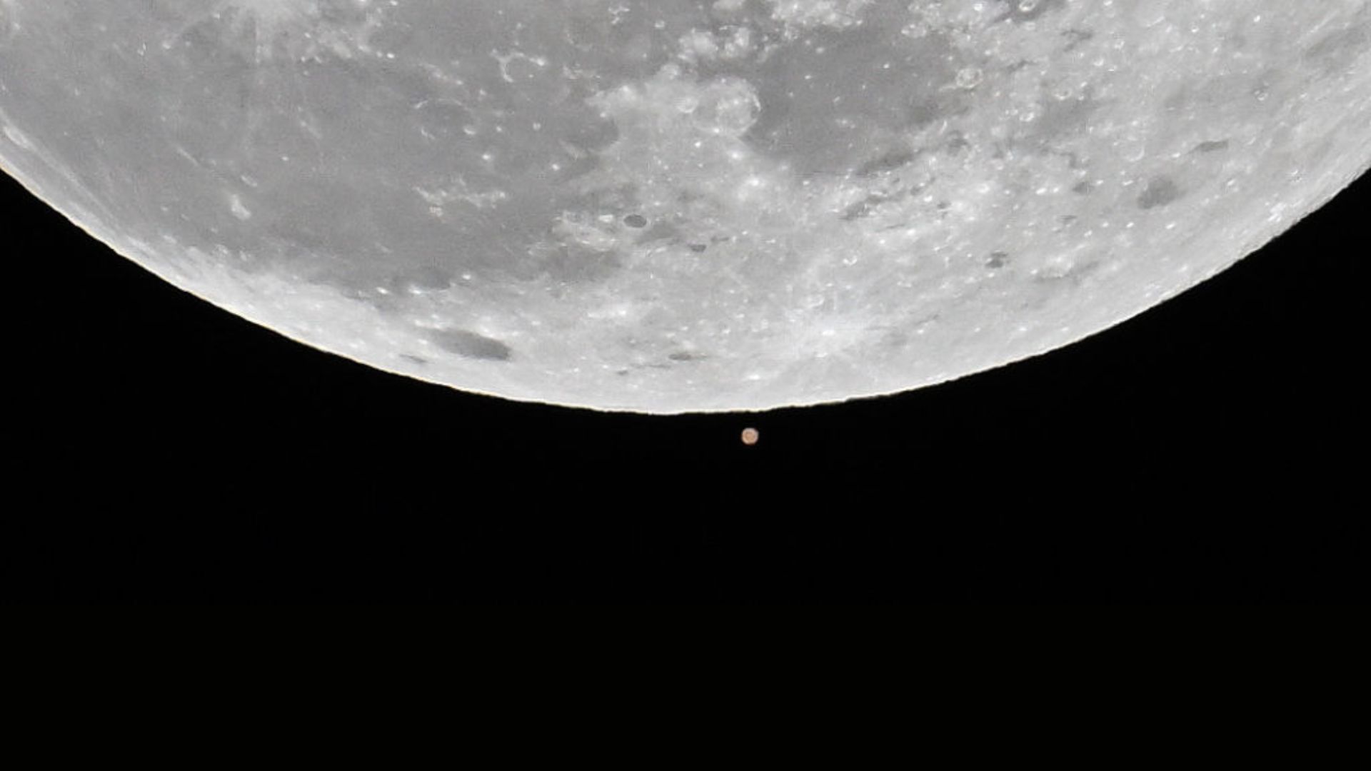 La première pleine lune de 2025 appelée « Lune du Loup » celle vue à côté de Mars s'élève au-dessus du ciel lors d'une occultation lunaire de Mars à Charlotte, aux États-Unis, le 13 janvier 2025. 