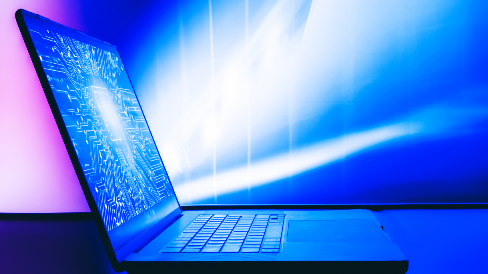 Un ordinateur portable avec une image lumineuse d’un circuit imprimé numérique sur l’écran. 