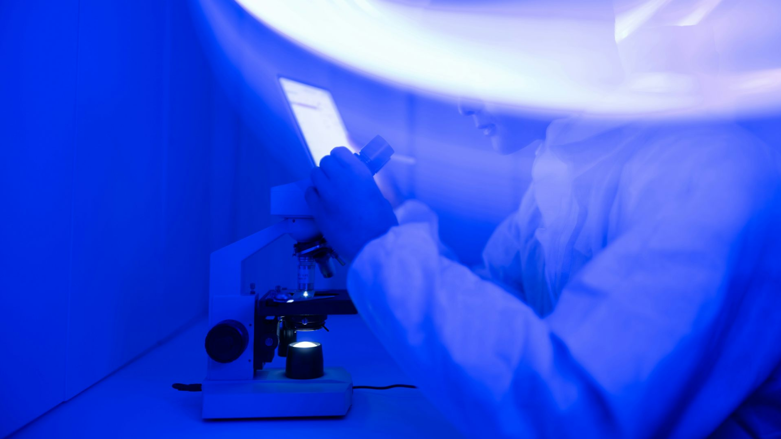 Un scientifique regarde un microscope.