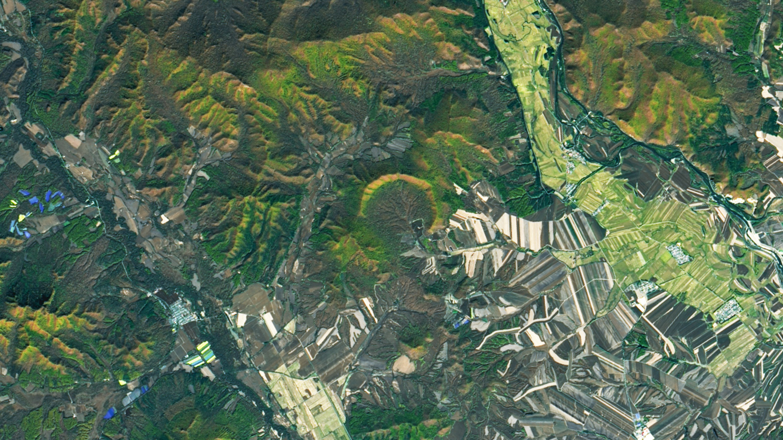 Photo satellite avec un cratère d'impact en forme de fer à cheval en son centre