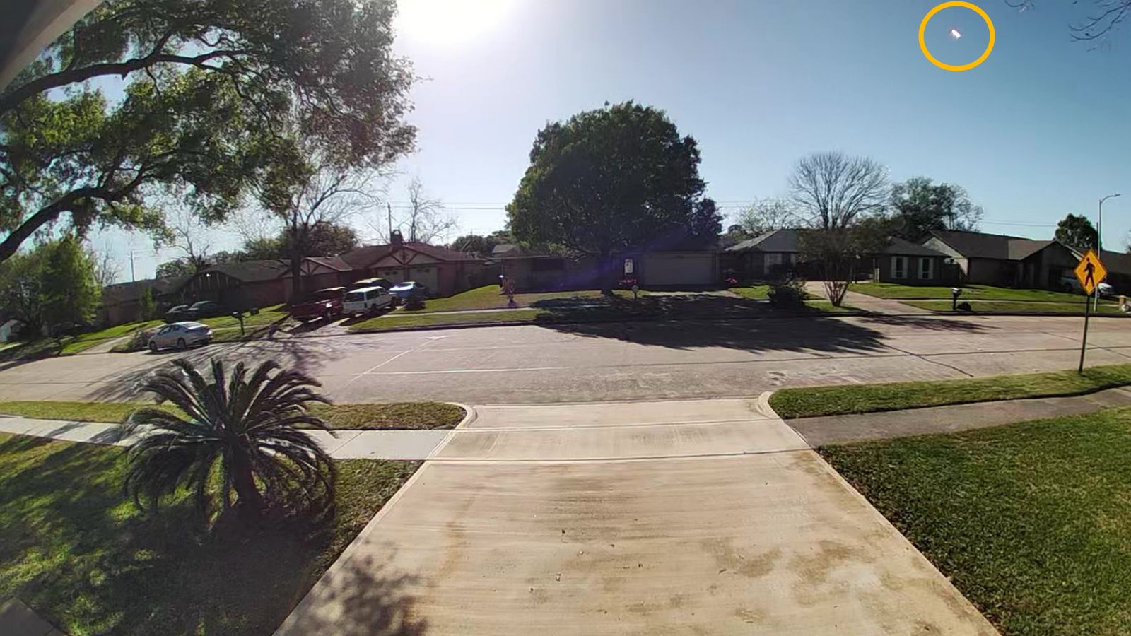 Doorbell camera photo of a fireball meteor streaking in the sky over a residential area