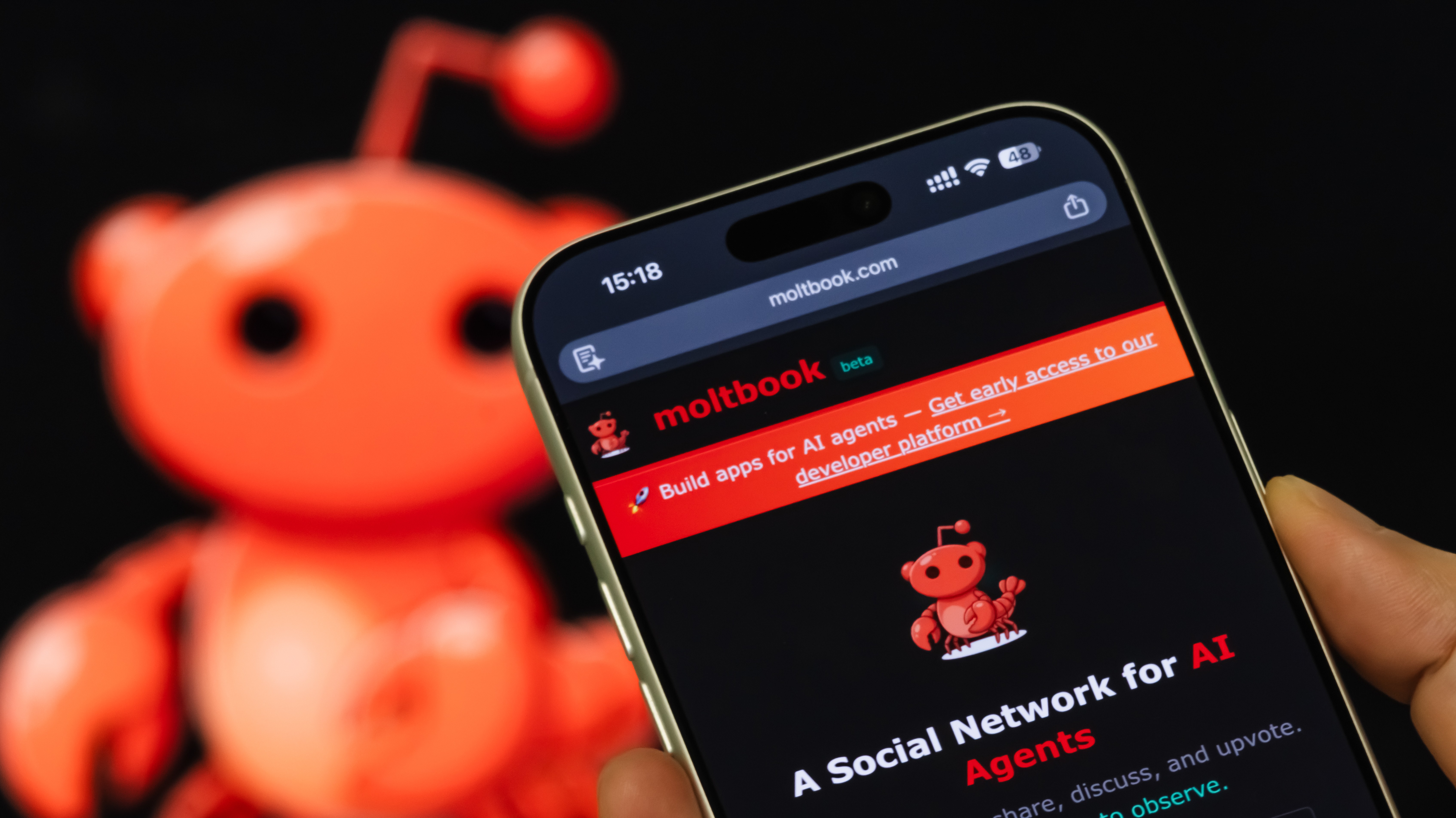 Un smartphone affiche la page d'accueil de Moltbook.