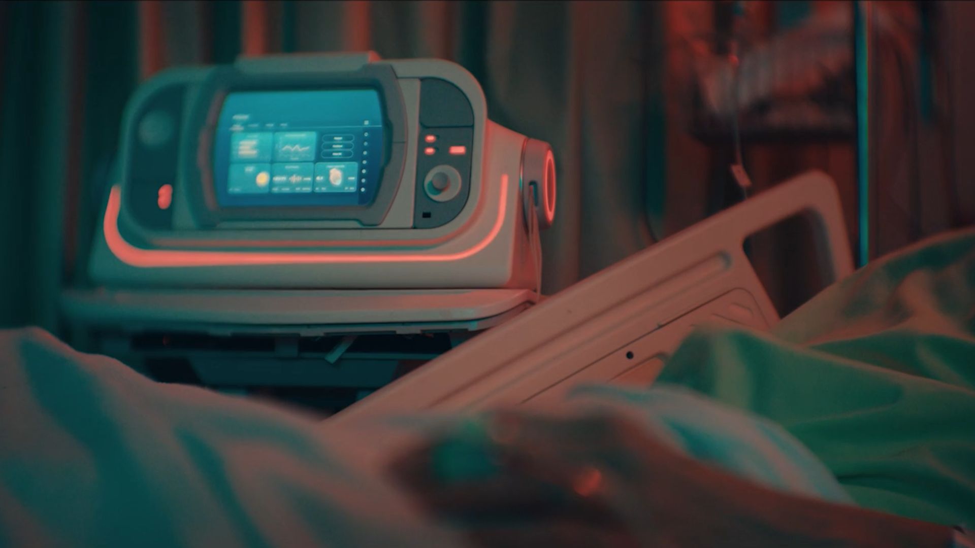 Image d'un appareil doté d'un écran et de cadrans placé à côté du lit d'un patient dans un hôpital