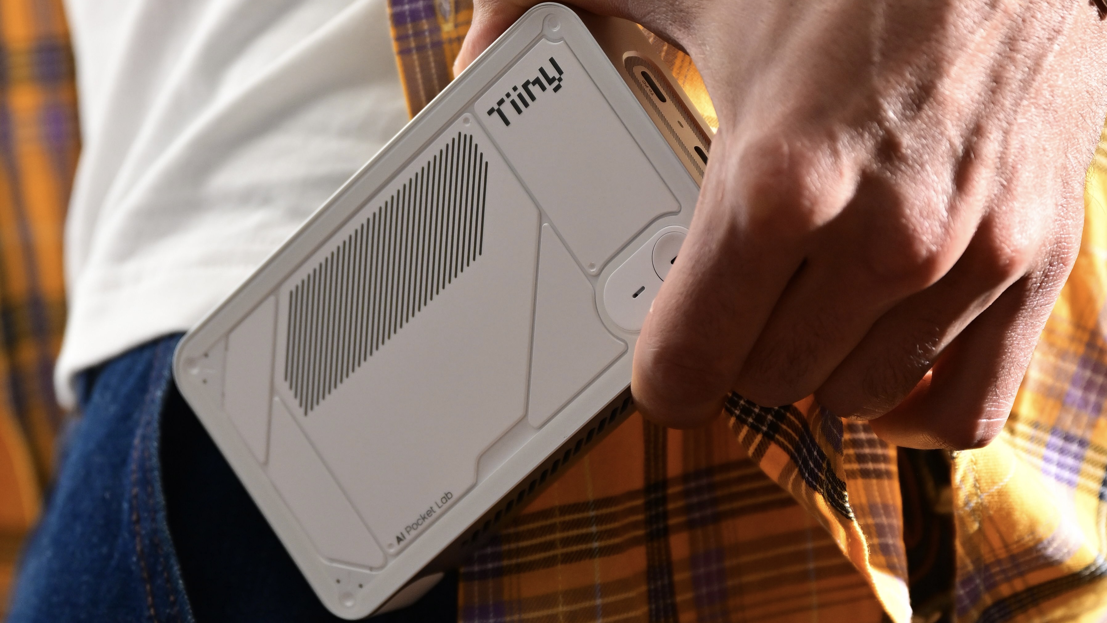 Le Tiiny AI tenu par un homme et placé dans sa poche.