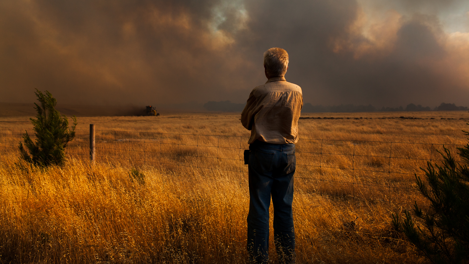 Un homme regarde un feu de brousse