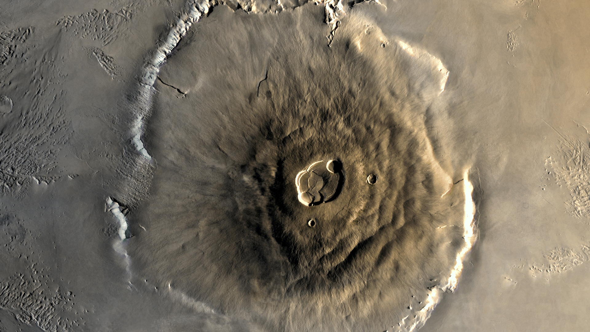 Un gros plan d'Olympus Mons à la surface de Mars, sa structure est un tas de lave brune dans un grand mont circulaire à la surface de la planète