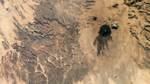 Des vrilles sombres de lave ancienne ont marqué un volcan sombre à côté d'un "crâne" dans le Sahara — La Terre vue de l'espace