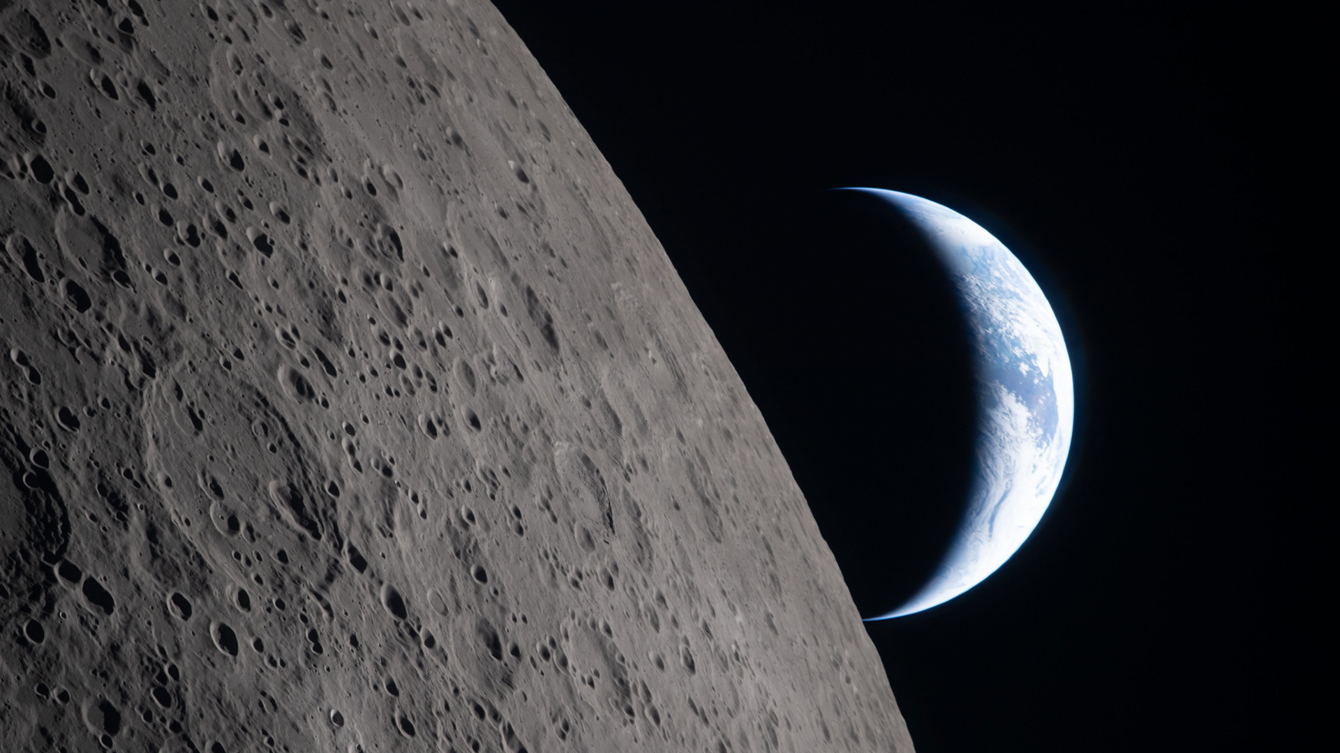 Une vue de la Terre depuis la Lune, avec la moitié de la Terre éclairée et la surface grise de la Lune au premier plan.