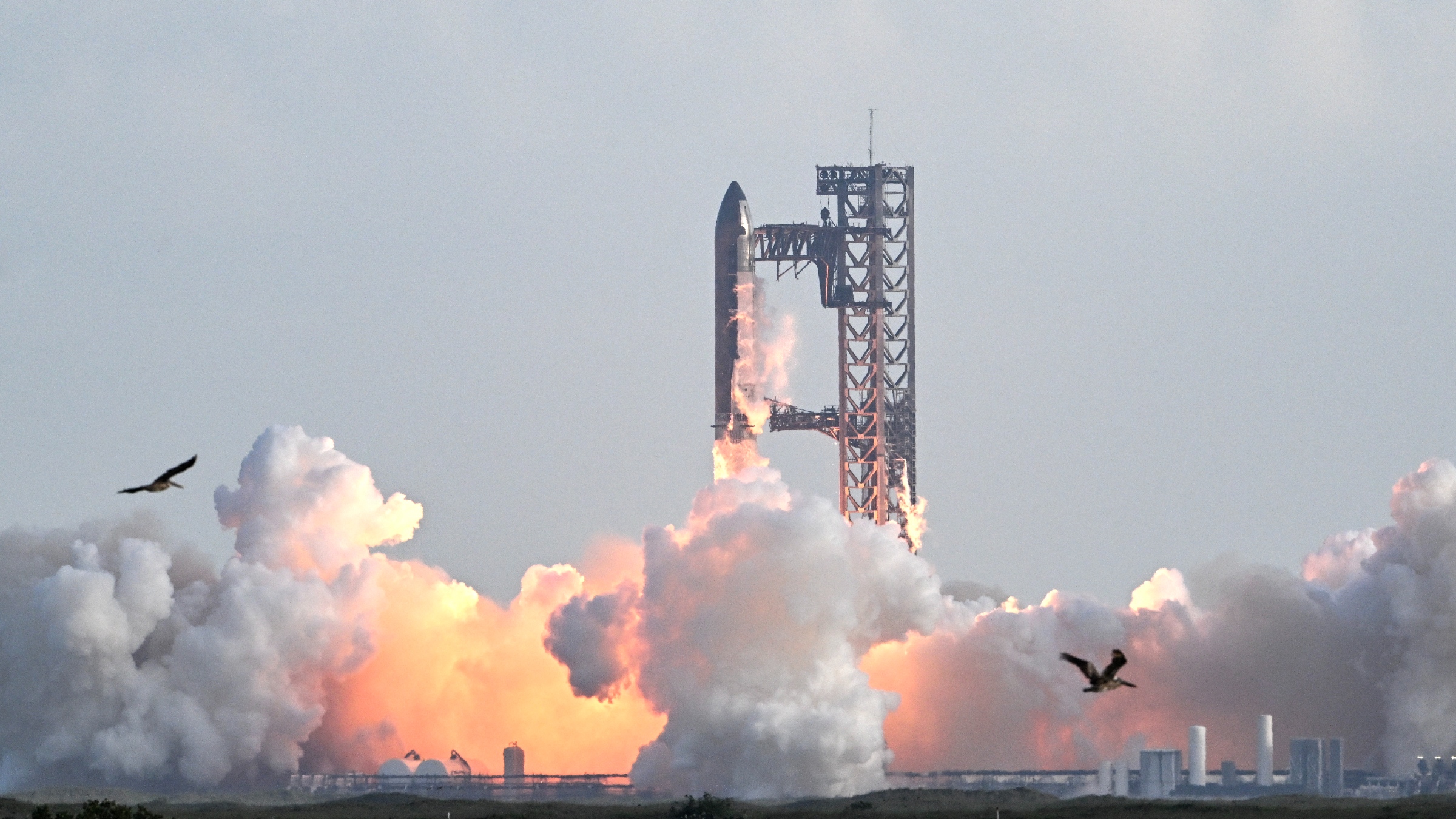 Une photo de la fusée Starship de SpaceX lancée depuis le sol avec un panache de feu et de fumée