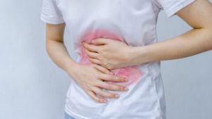 Image shows a person clutching their stomach