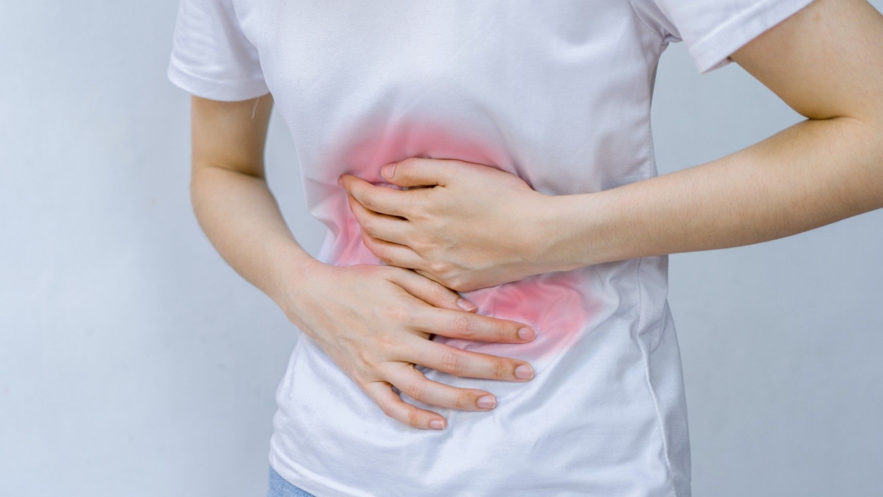 Image shows a person clutching their stomach