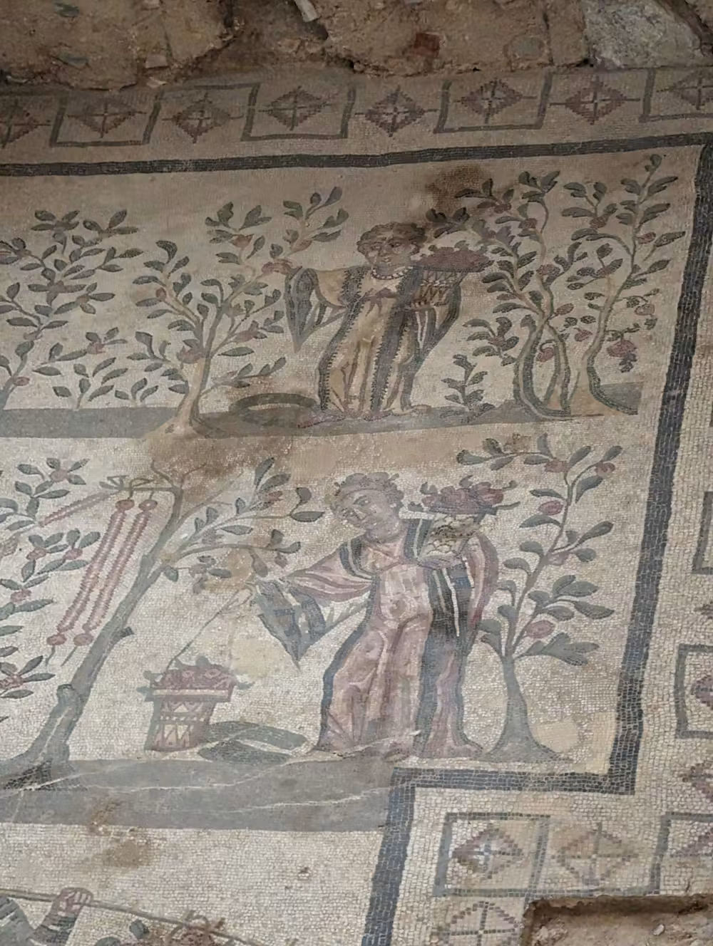 Un gros plan d'une mosaïque d'une femme dans un jardin.