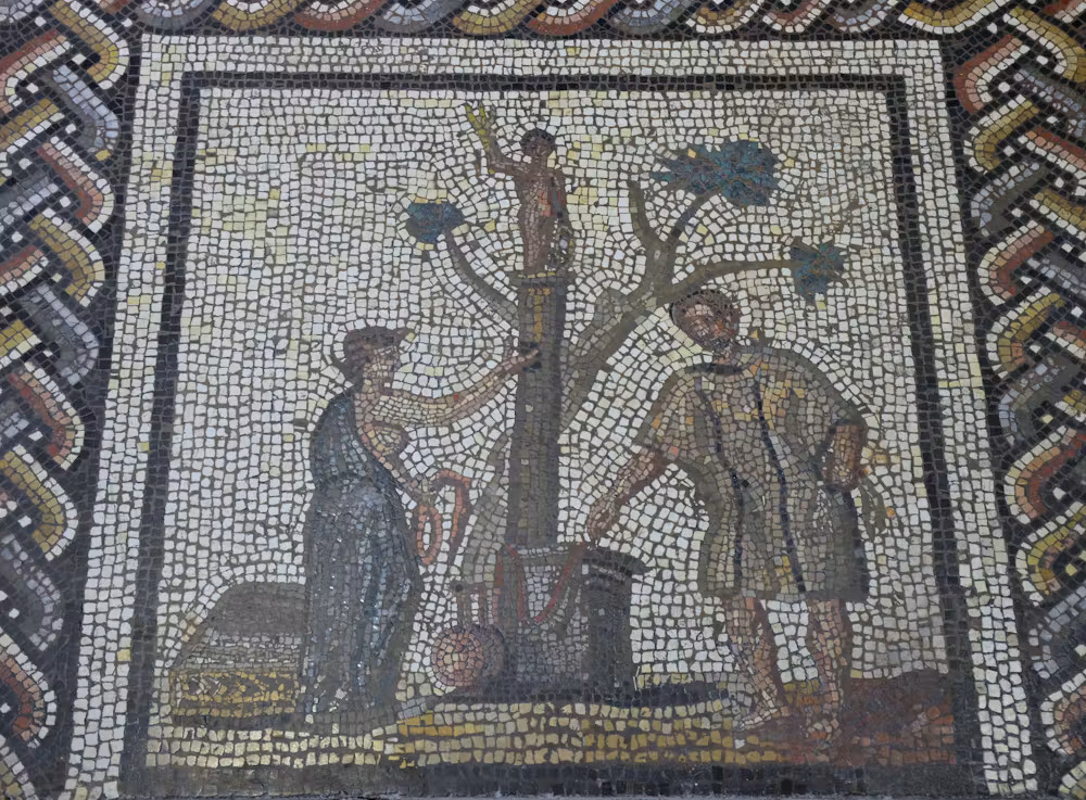 Un gros plan d’une mosaïque avec des gens autour d’un arbre.