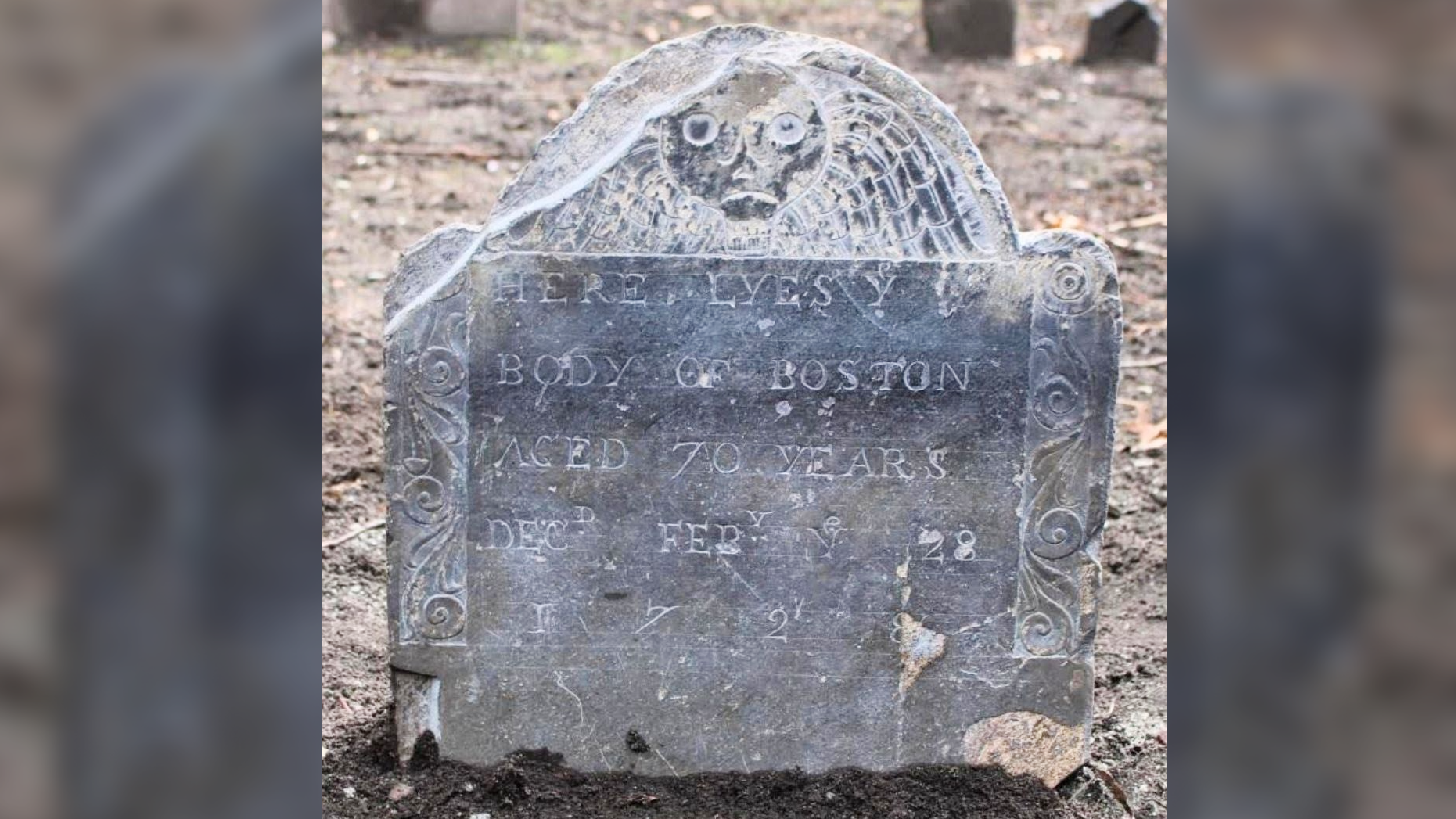 une pierre tombale grise dans un paysage aride avec une décoration et une inscription de tête de mort