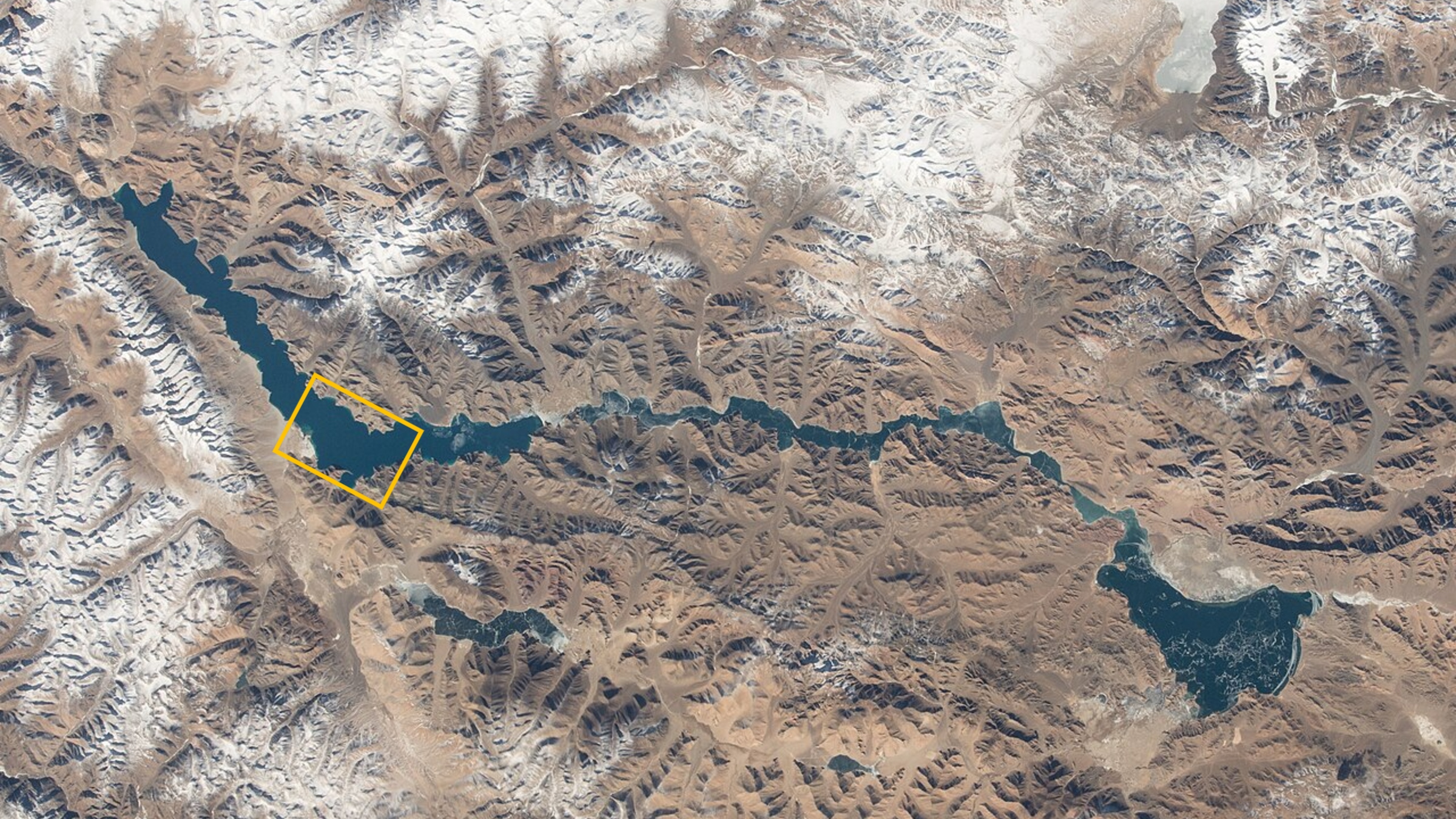 Une photo satellite du lac Pangong avec un cadre orange soulignant l'emplacement des photos en gros plan.