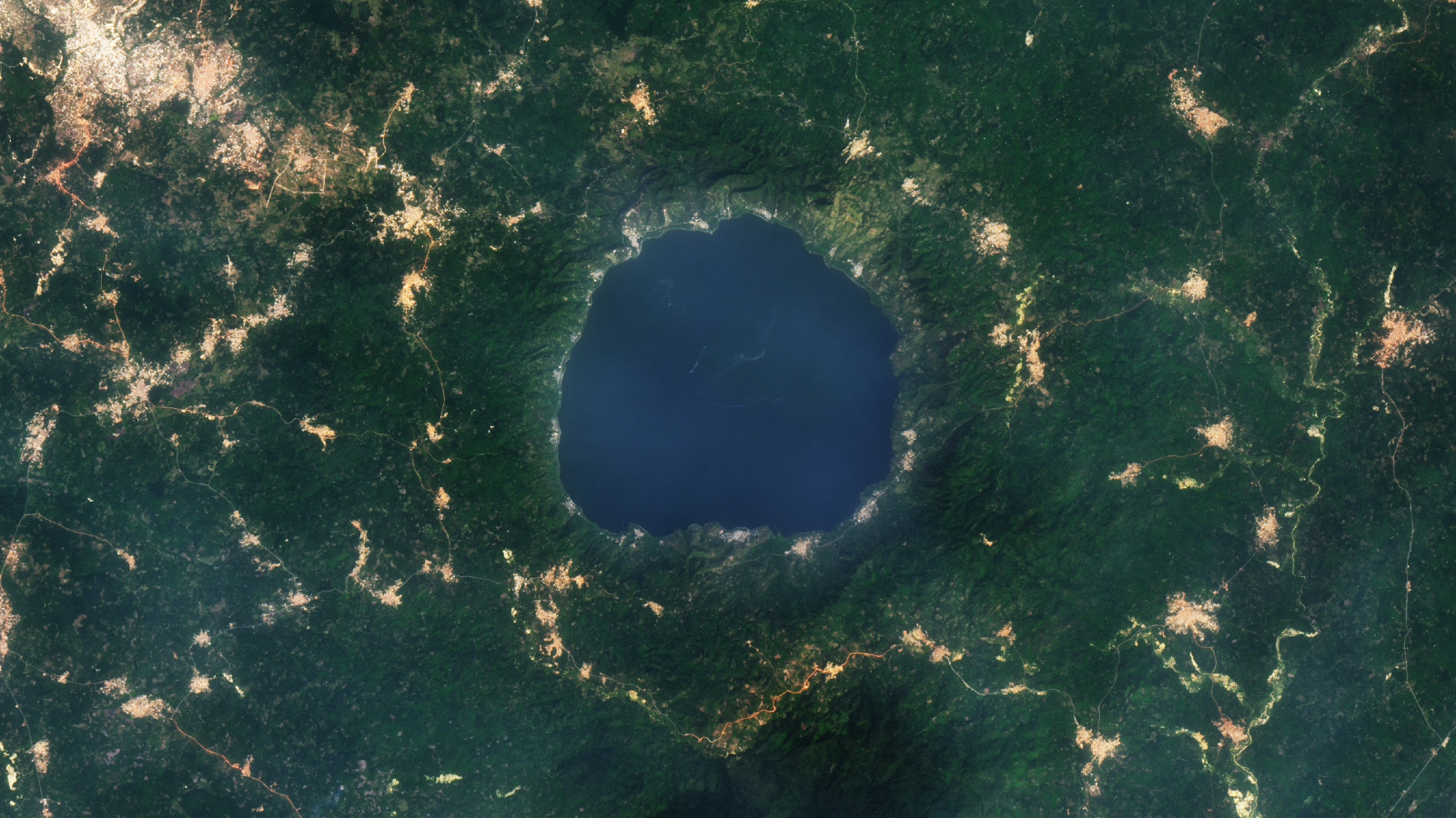 Une photo satellite de 2015 montrant une série de vrilles dorées entourant un lac bleu rond