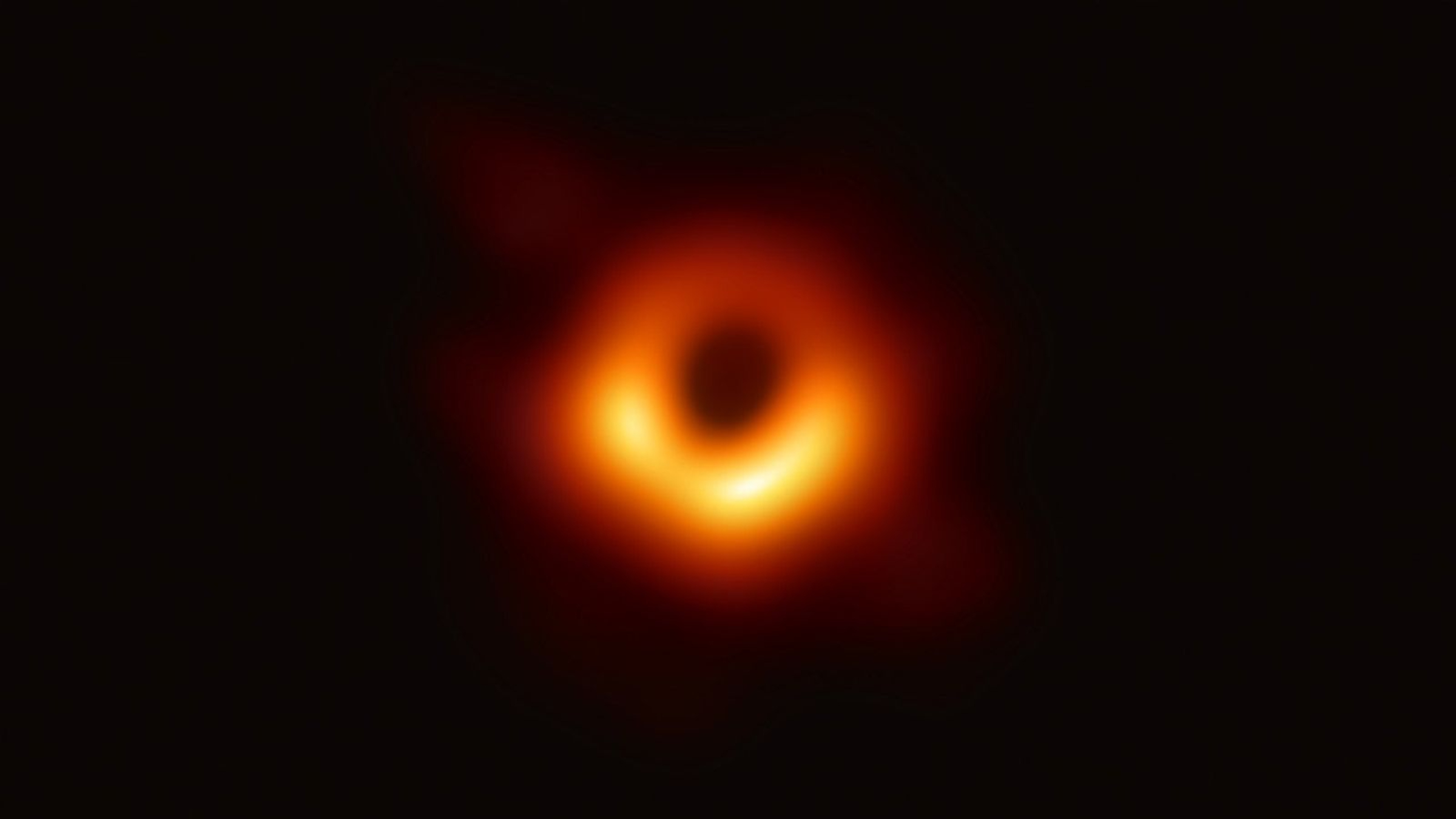 La première image directe d'un trou noir montrant un anneau orange flou autour d'un point sombre central