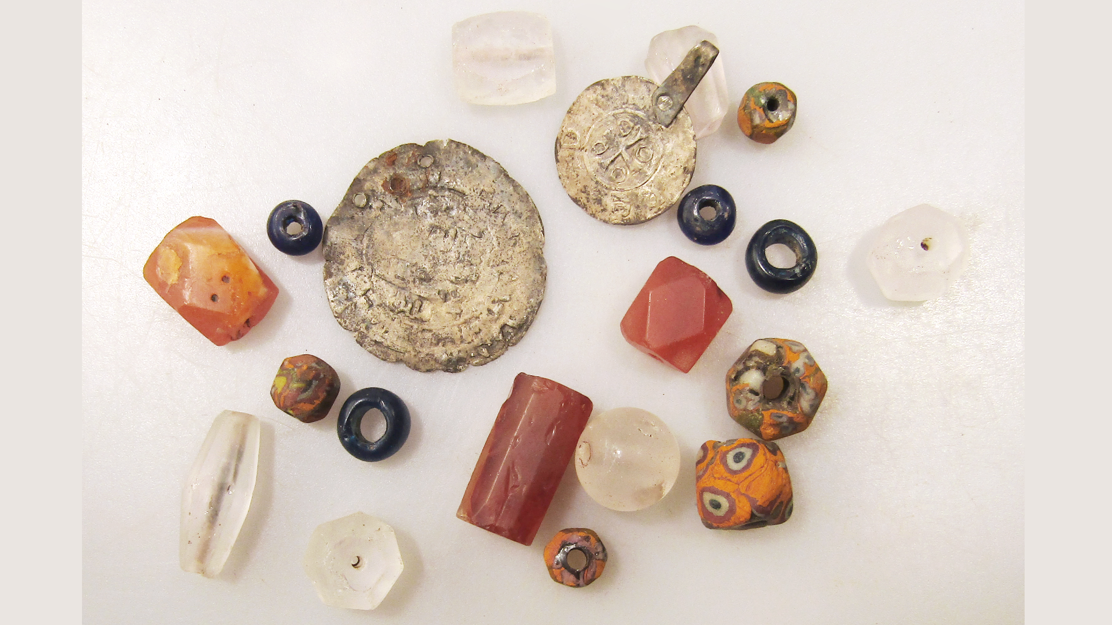 un ensemble d'une douzaine de perles et de pièces sur un fond blanc