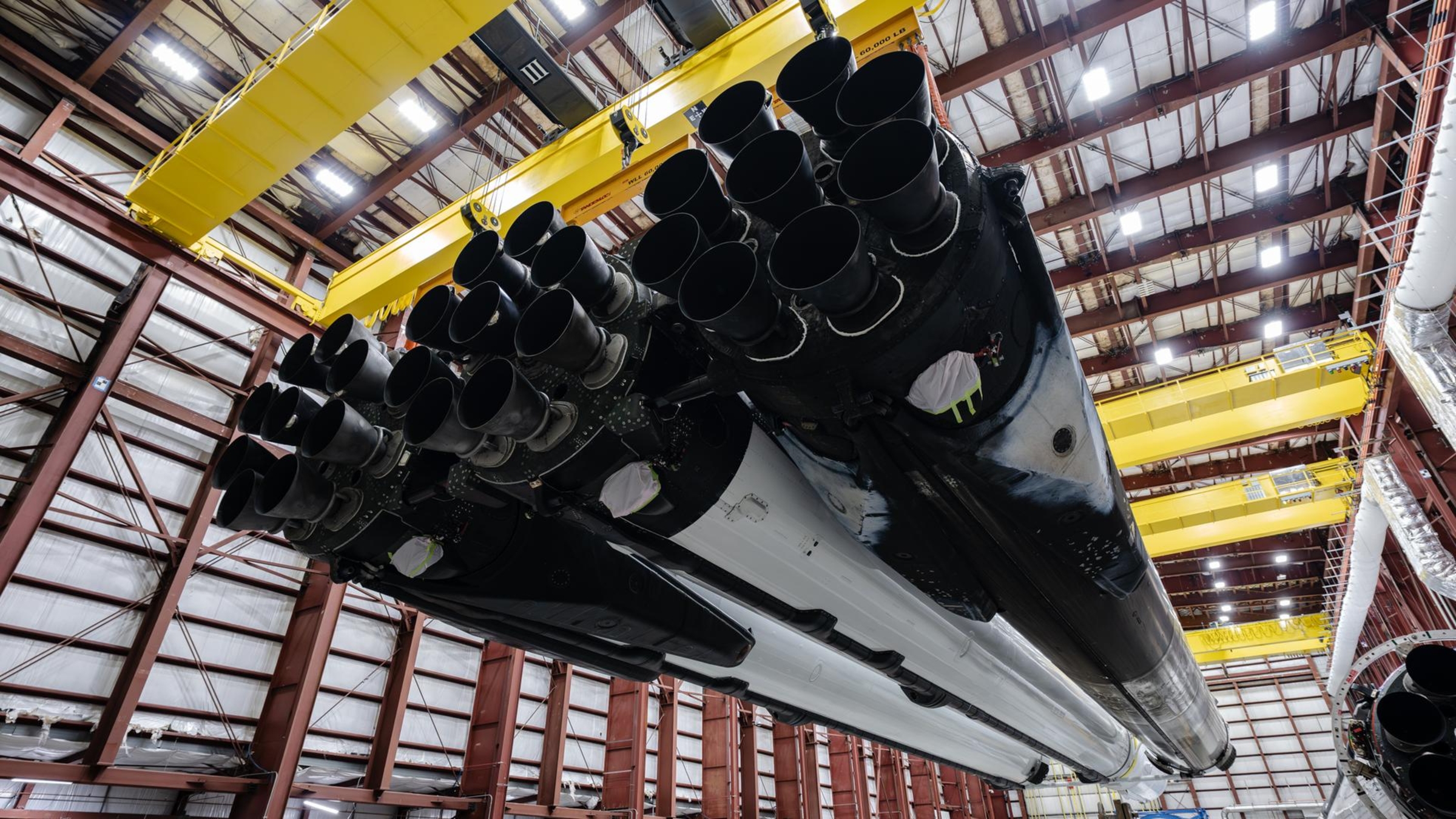 Une photo des propulseurs de fusée Falcon Heavy suspendus dans un entrepôt