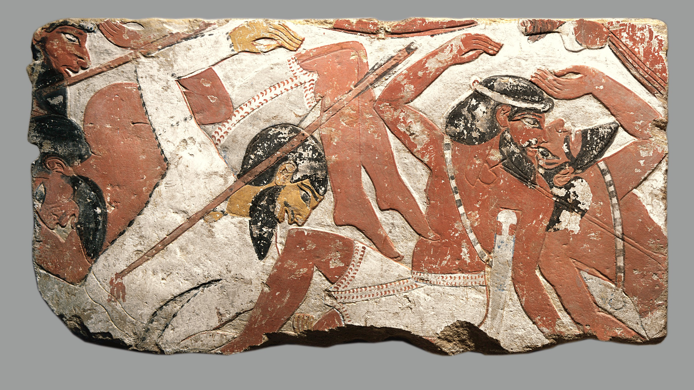 fragment de pierre peinte sculpté d'images de personnes piétinées par un char