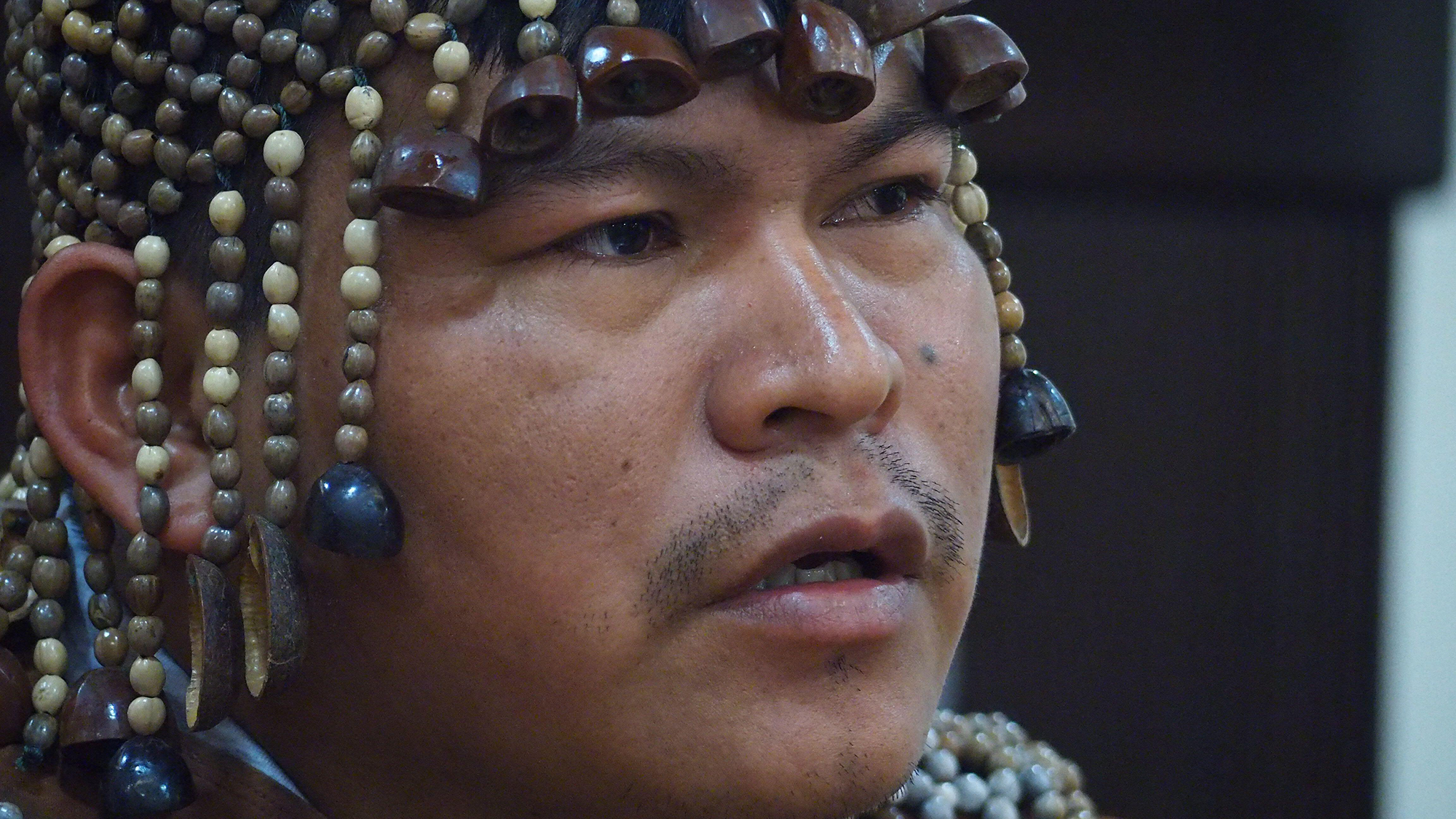 Un gros plan d'un homme portant une coiffe de perles