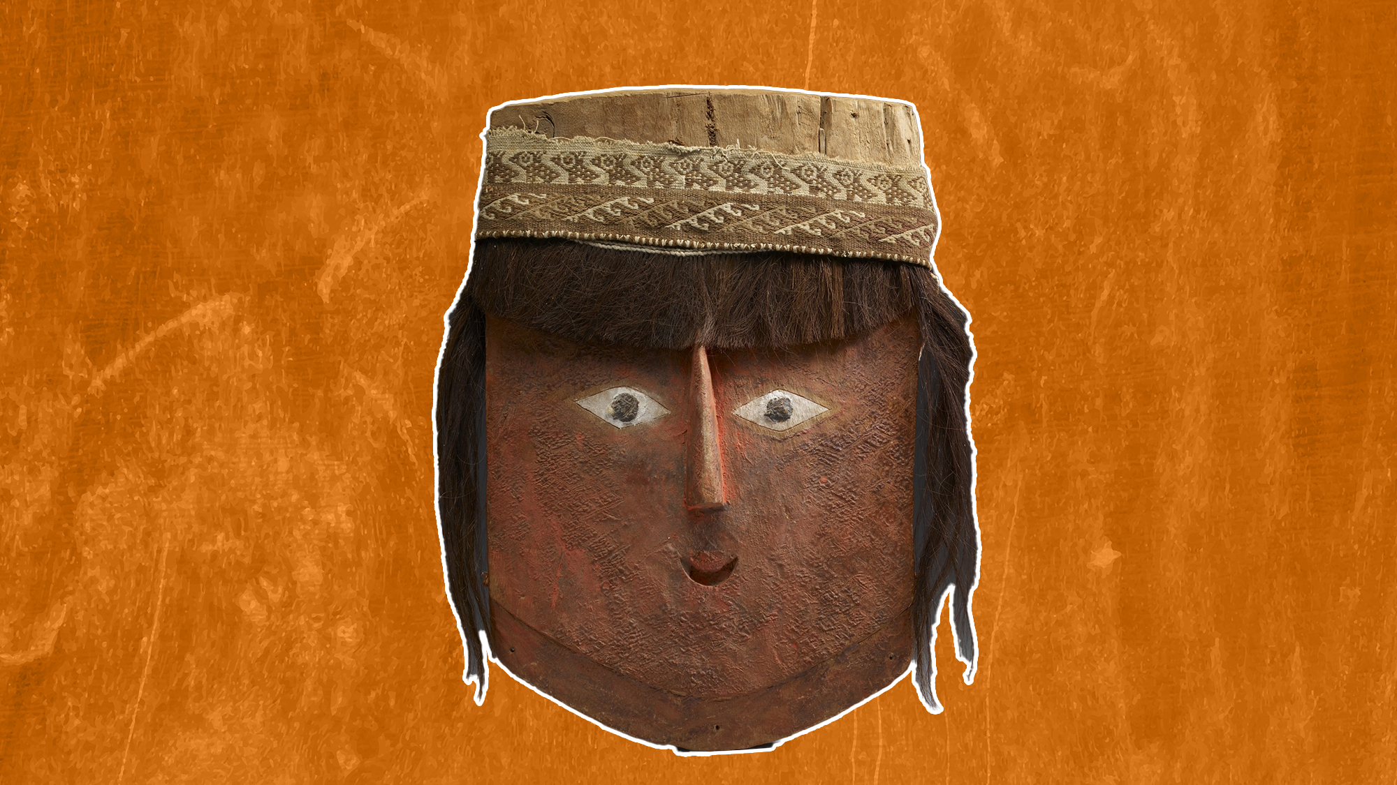un masque en bois peint en rouge en forme de visage humain stylisé avec des cheveux humains attachés