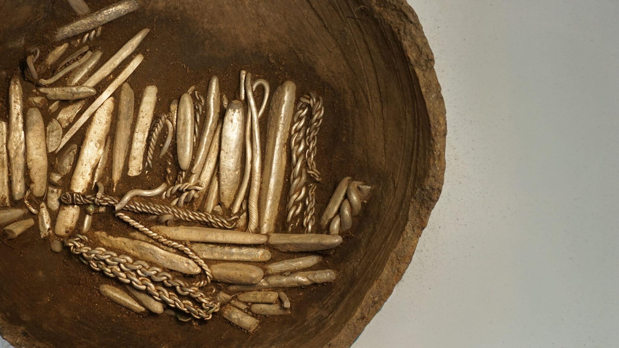 Un gros plan d'objets métalliques provenant d'un trésor Viking contre une surface propre