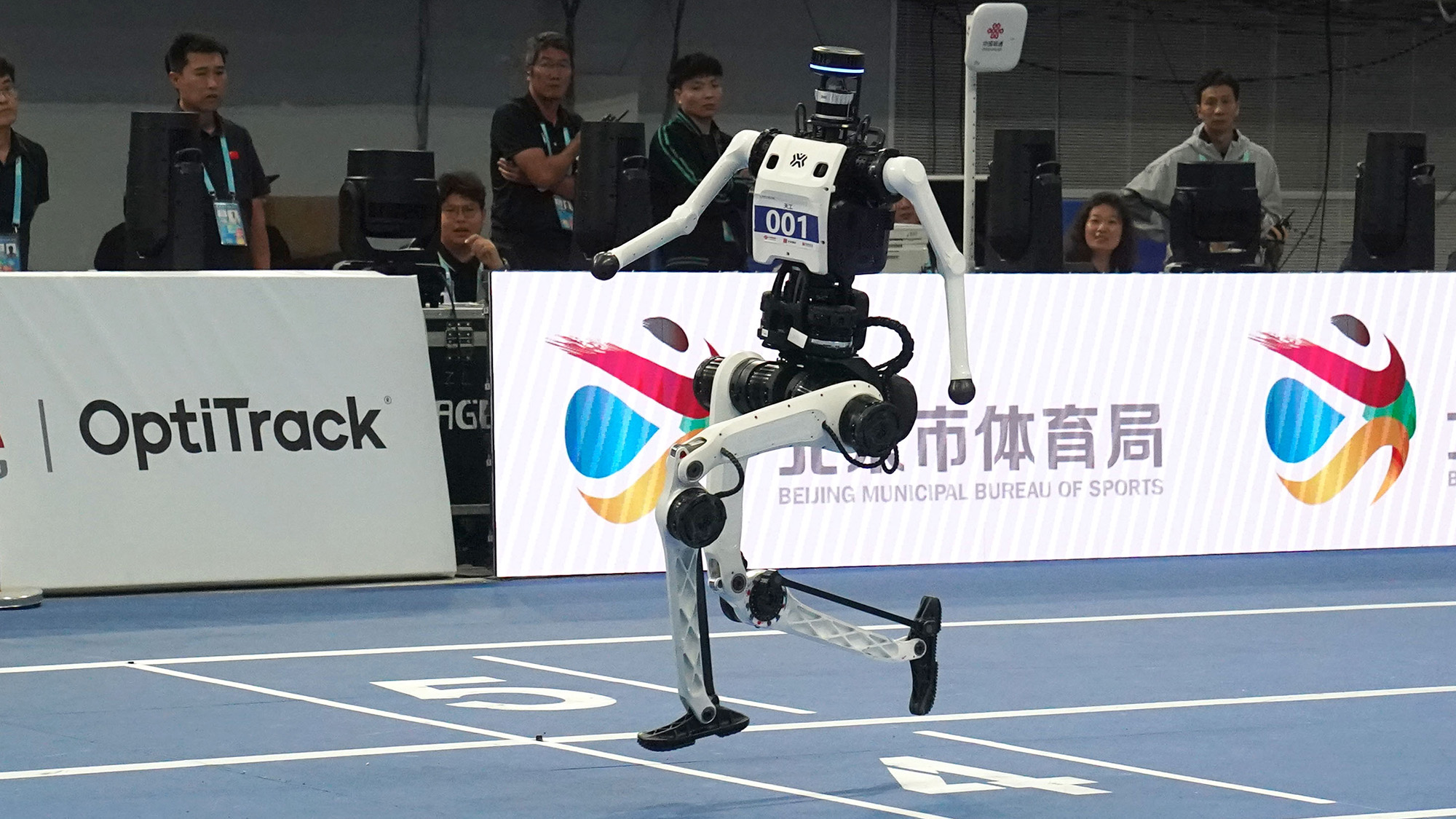 Un robot humanoïde court sur une piste bleue