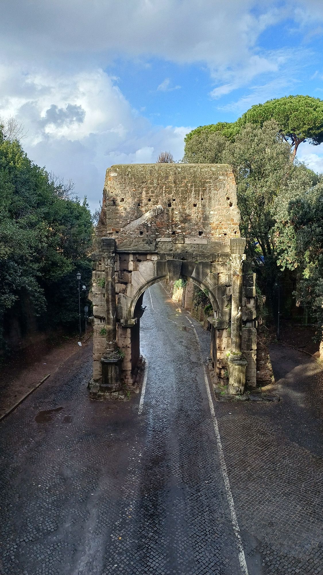 Une arche en pierre est visible au-dessus d'une route.