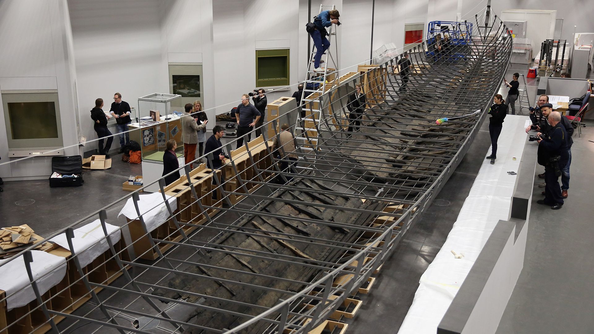 Un groupe d'ouvriers construit un grand bateau en bois.