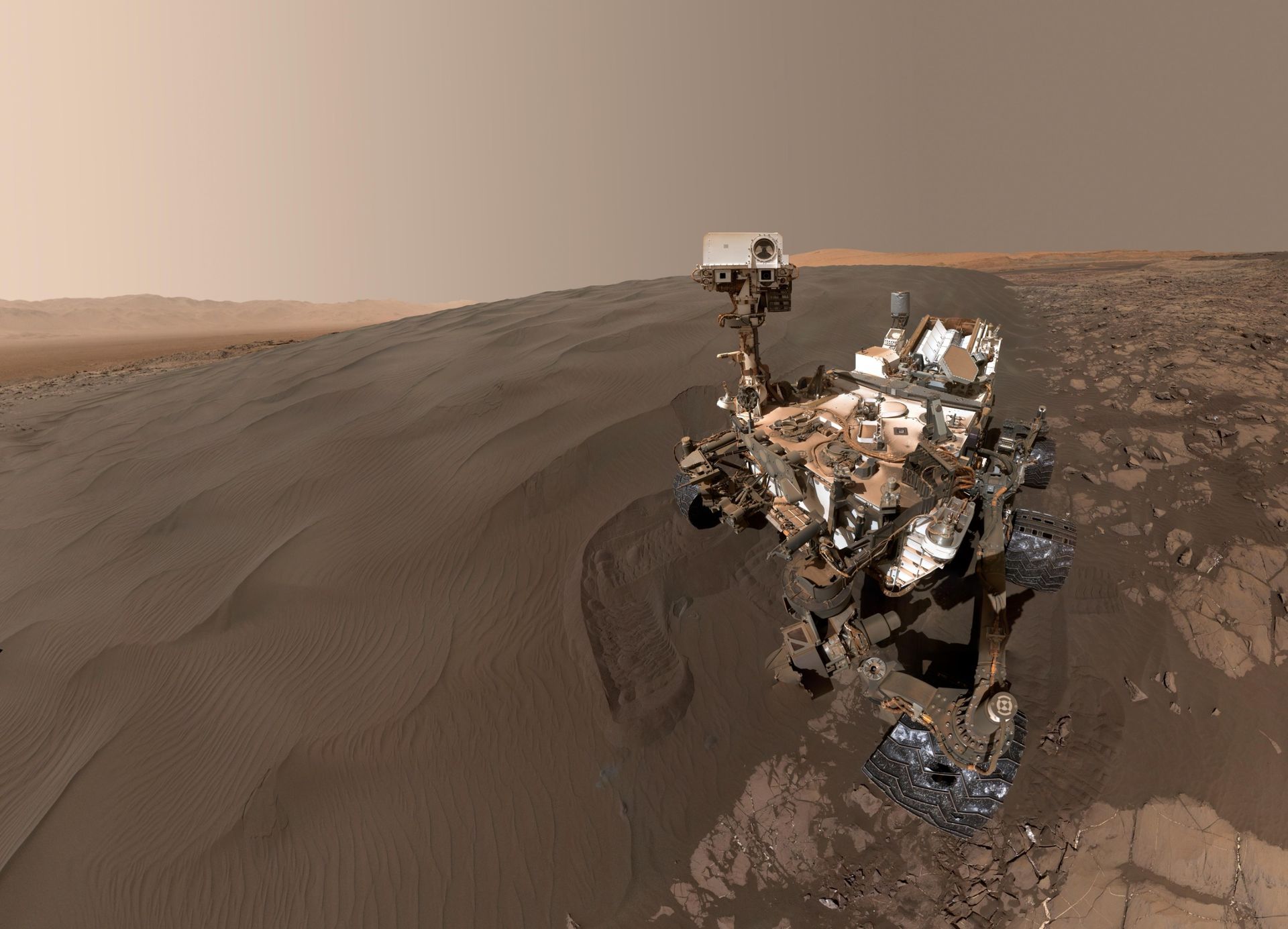 Un rover est aperçu sur une surface marron boueuse.