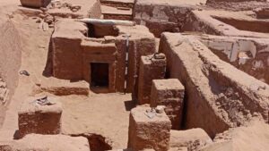 A zoomed out view of a half-unearthed tomb in the desert.