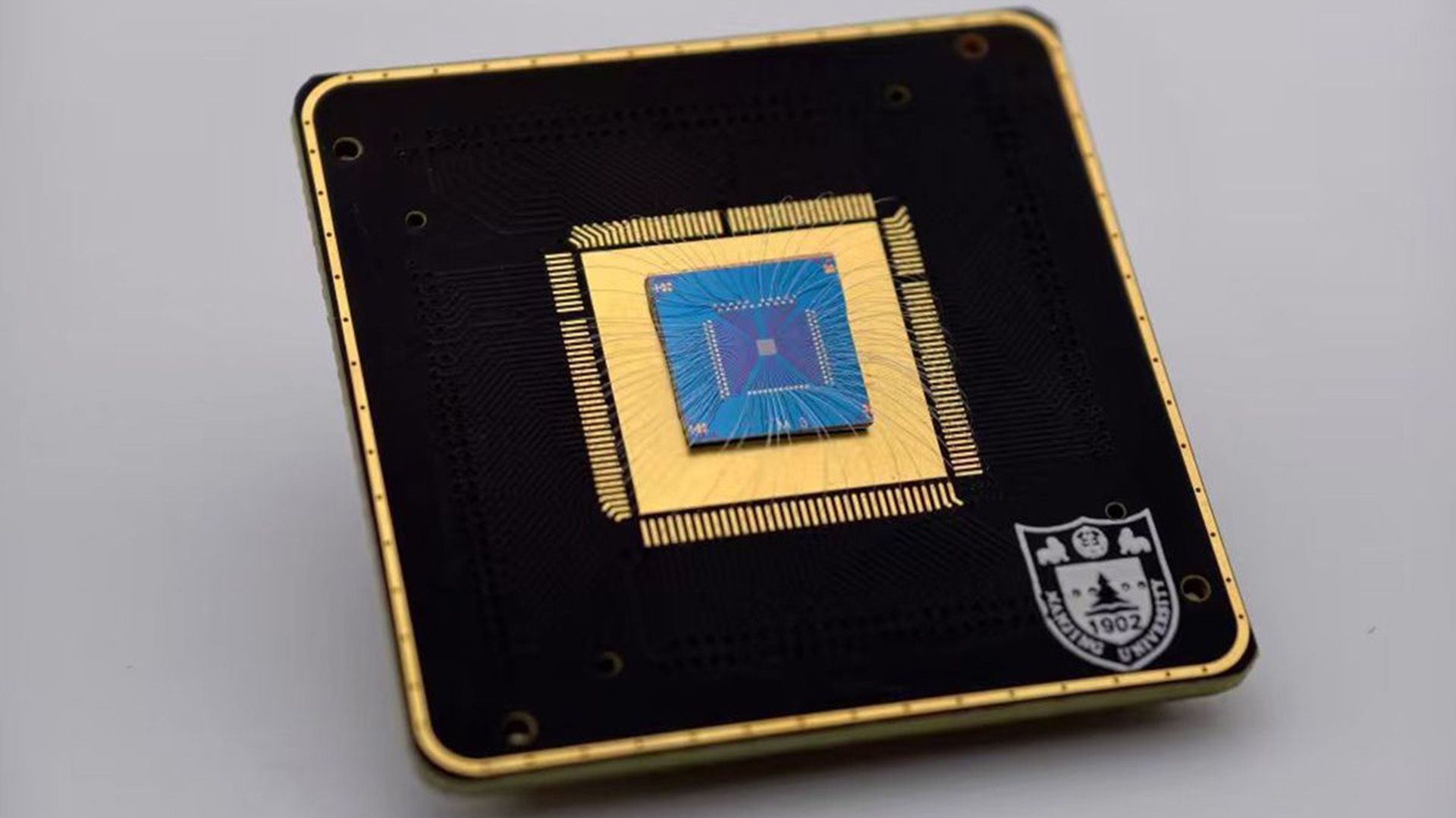 A close up of a brass and dark square with a circuit board on it.